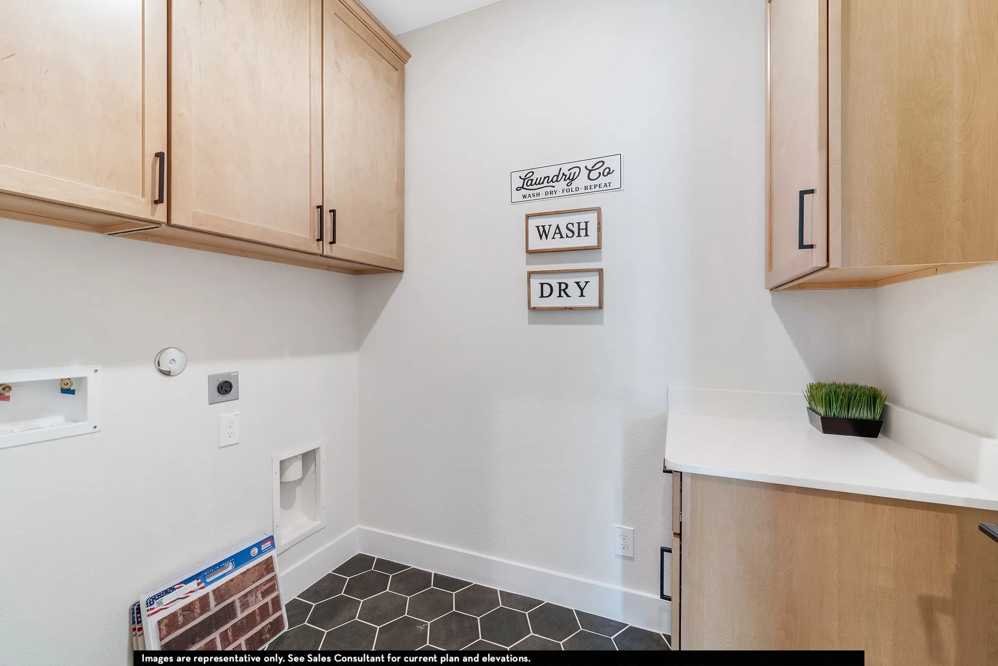 Light wood-finish cabinetry, hexagonal floor tiling, and a white countertop