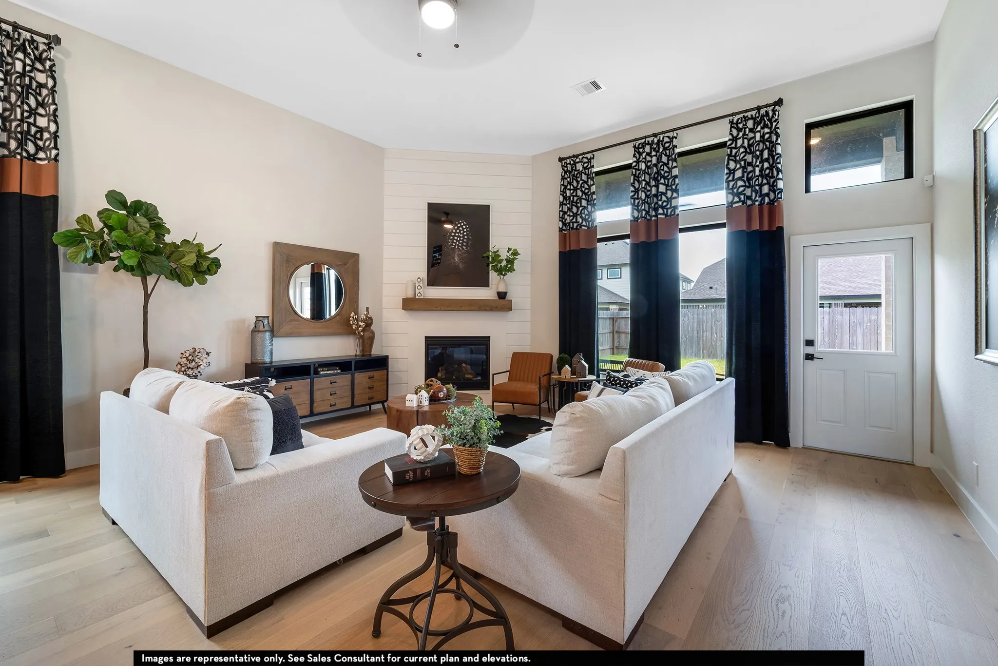 Living area with wood-finish flooring, a white shiplap fireplace surround, and a natural wood mantel