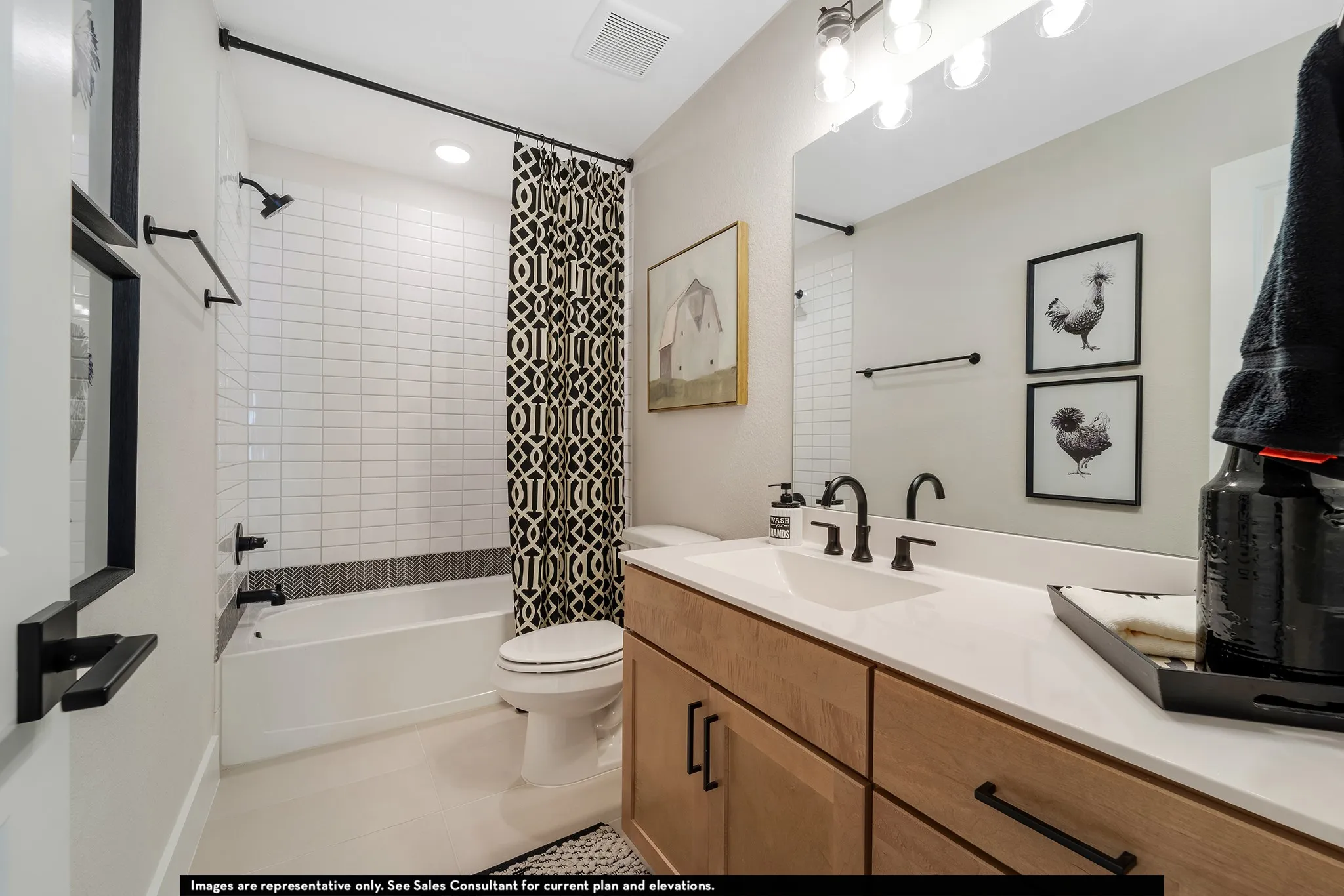 Bathroom featuring a light wood-finish vanity with a white countertop, undermount sink, and black fixtures