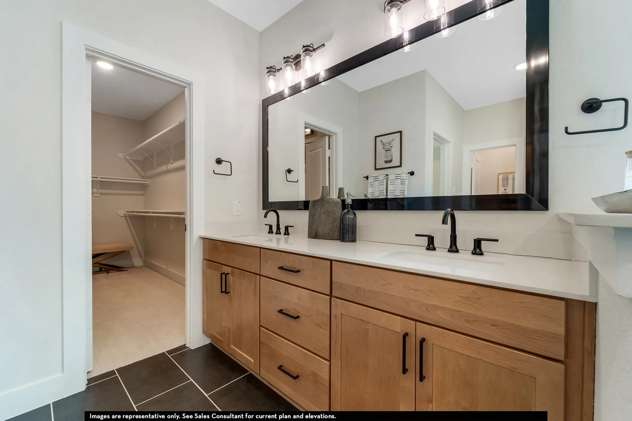 Double vanity with light wood cabinetry and matte black hardware