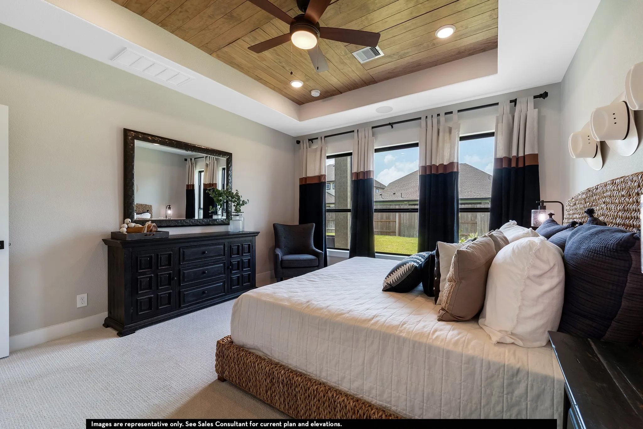 Tray ceiling with wood-finish paneling, ceiling fan with integrated lighting, recessed lighting, and wall-to-wall carpeting