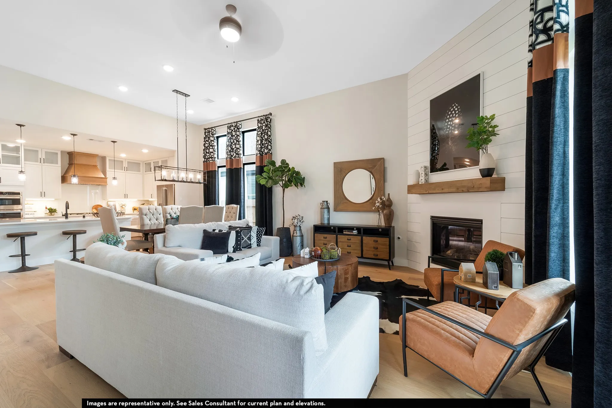 Open-concept living space featuring wood-finish flooring, a contemporary fireplace with a shiplap accent wall, and recessed lighting