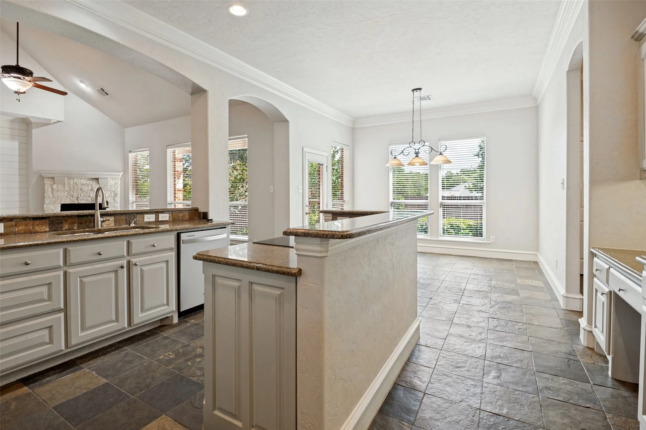 Kitchen featuring granite countertops, light-toned cabinetry, tile flooring, and integrated appliances