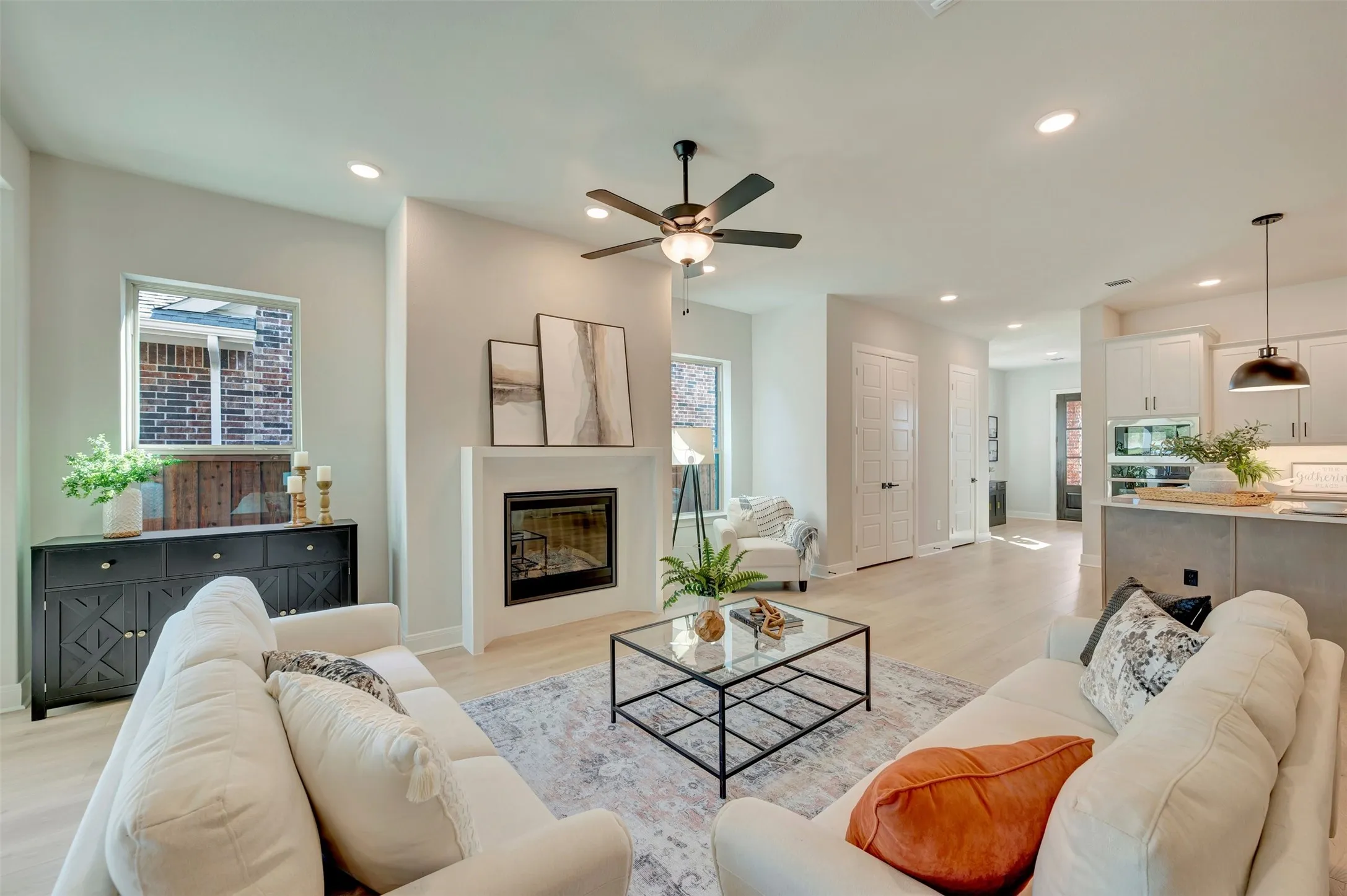 Open-concept living area with wood-finish flooring, recessed lighting, and a ceiling fan