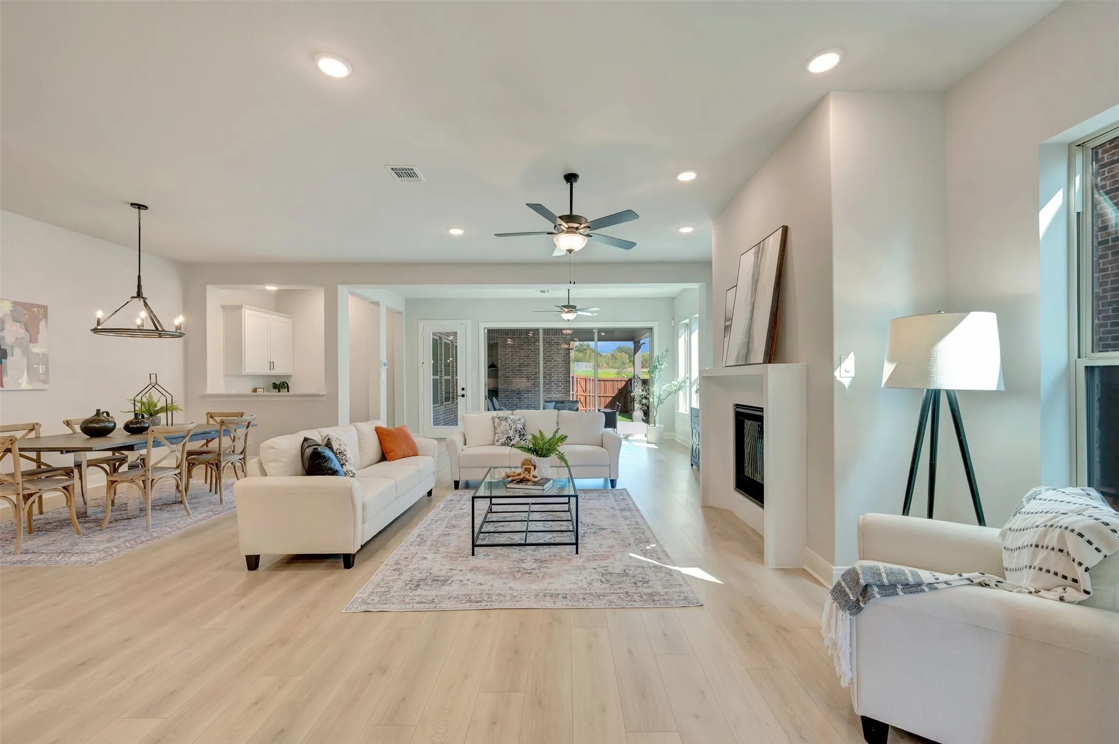 Spacious interior featuring light wood-finish flooring, recessed lighting, and a contemporary fireplace