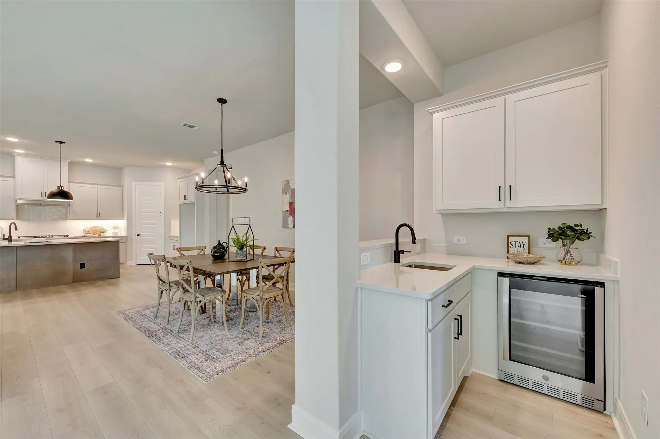 White cabinetry with black hardware, integrated beverage cooler, and under-mount sink