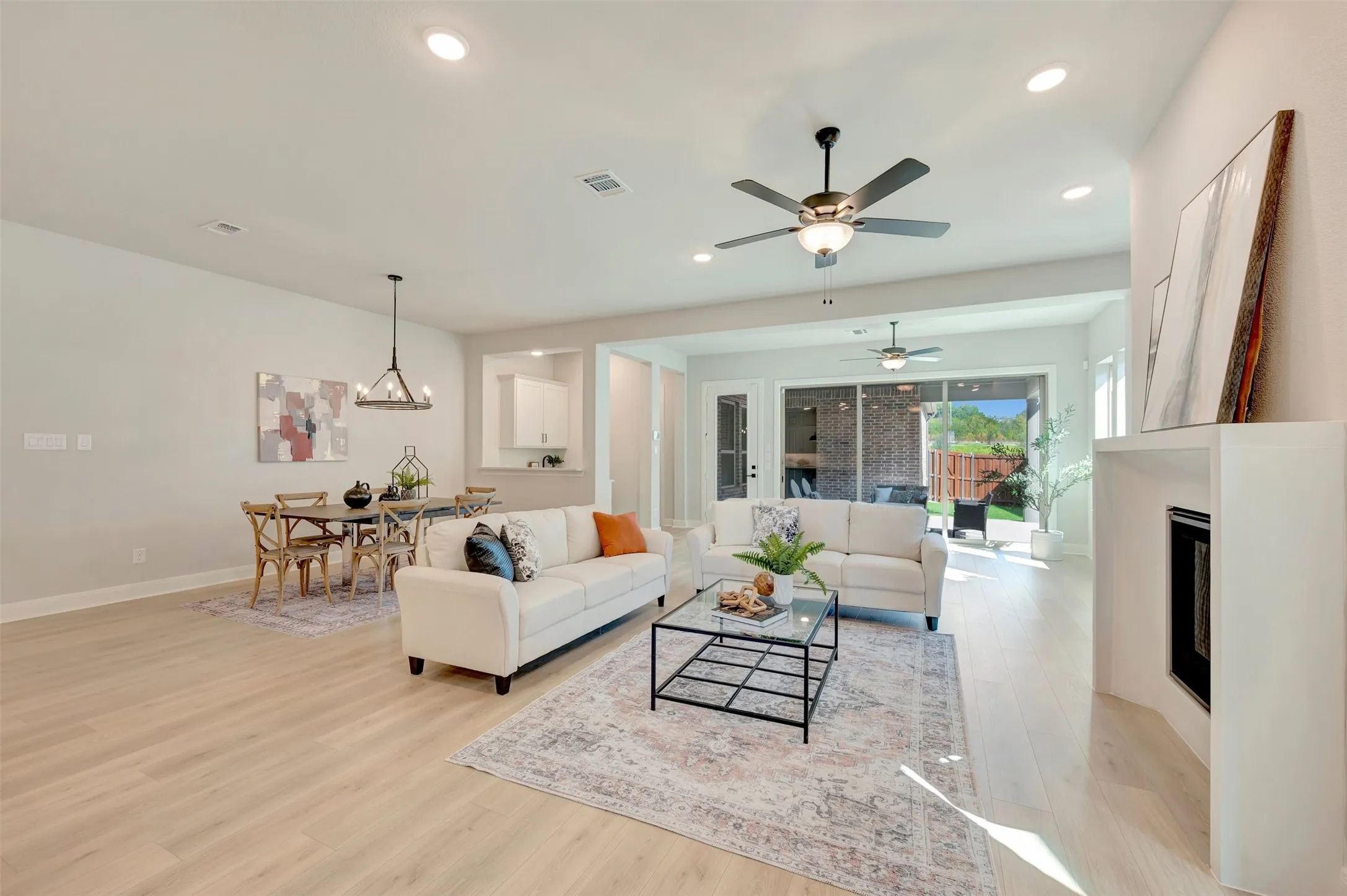 Open-concept living space featuring wood-finish flooring, recessed lighting, and a built-in fireplace