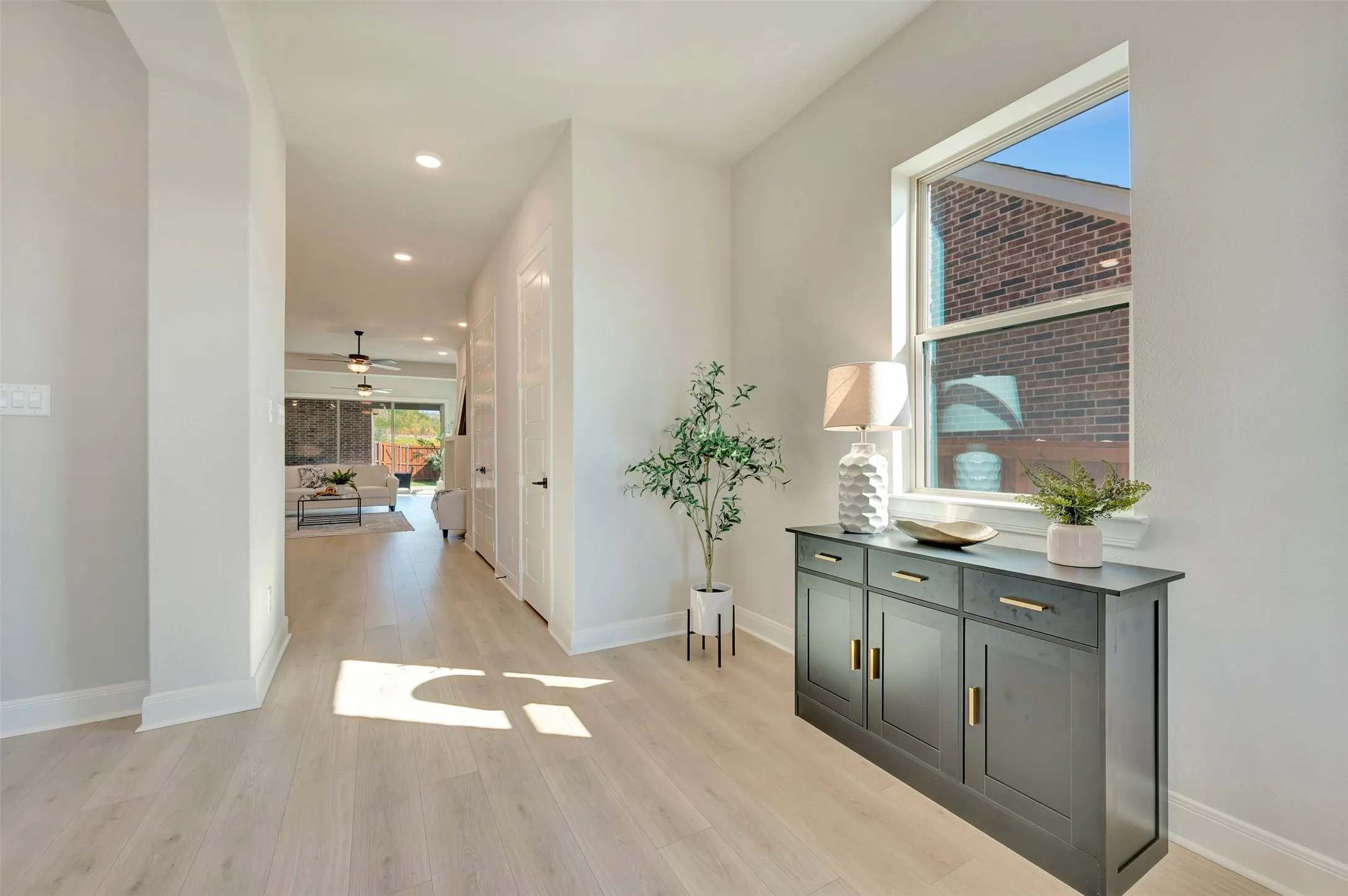 Bright entryway featuring light-toned wood-finish flooring, a wall-mounted window, and recessed lighting