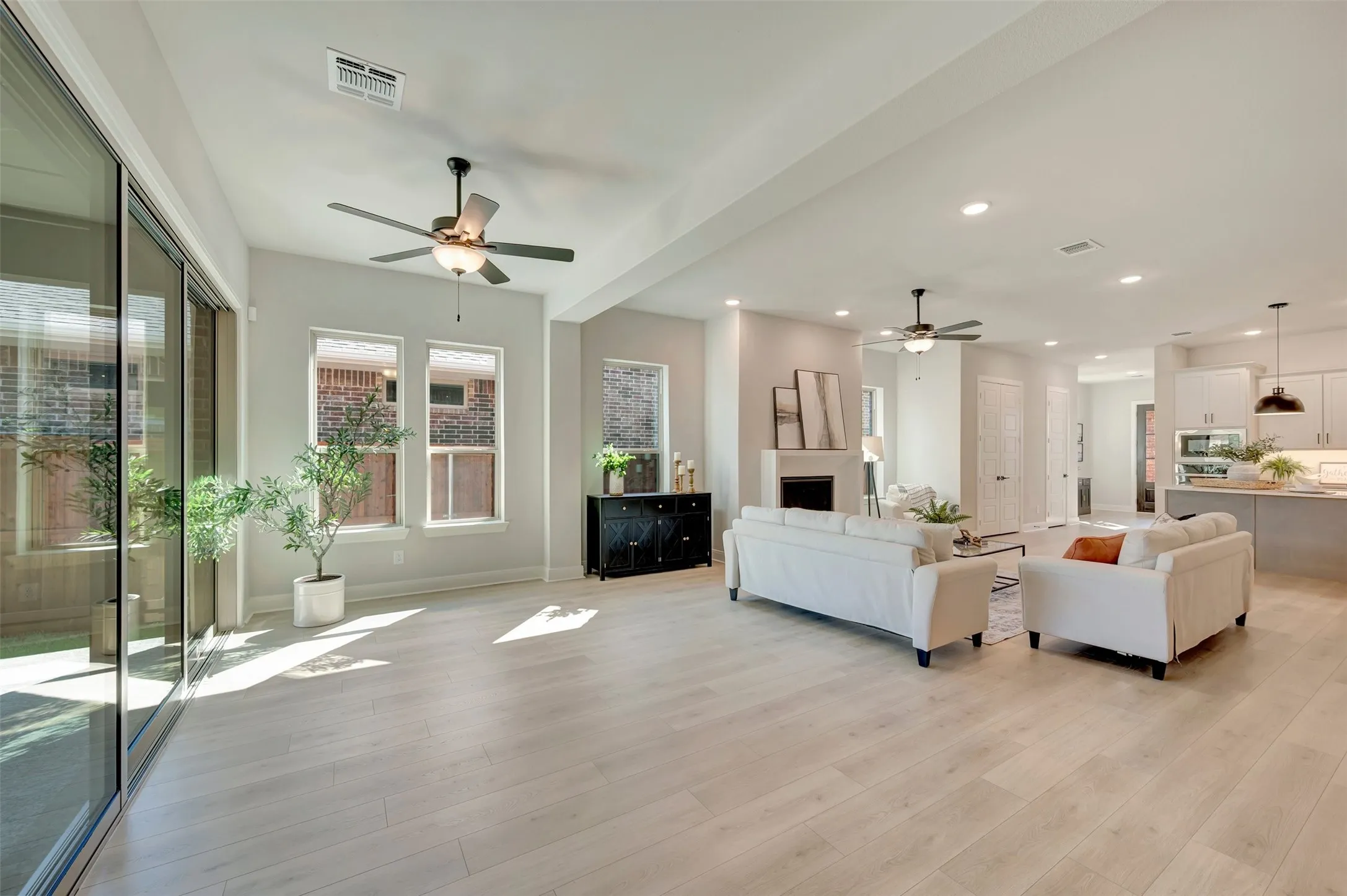 Spacious living area featuring wood-finish flooring, recessed lighting, and ceiling fans