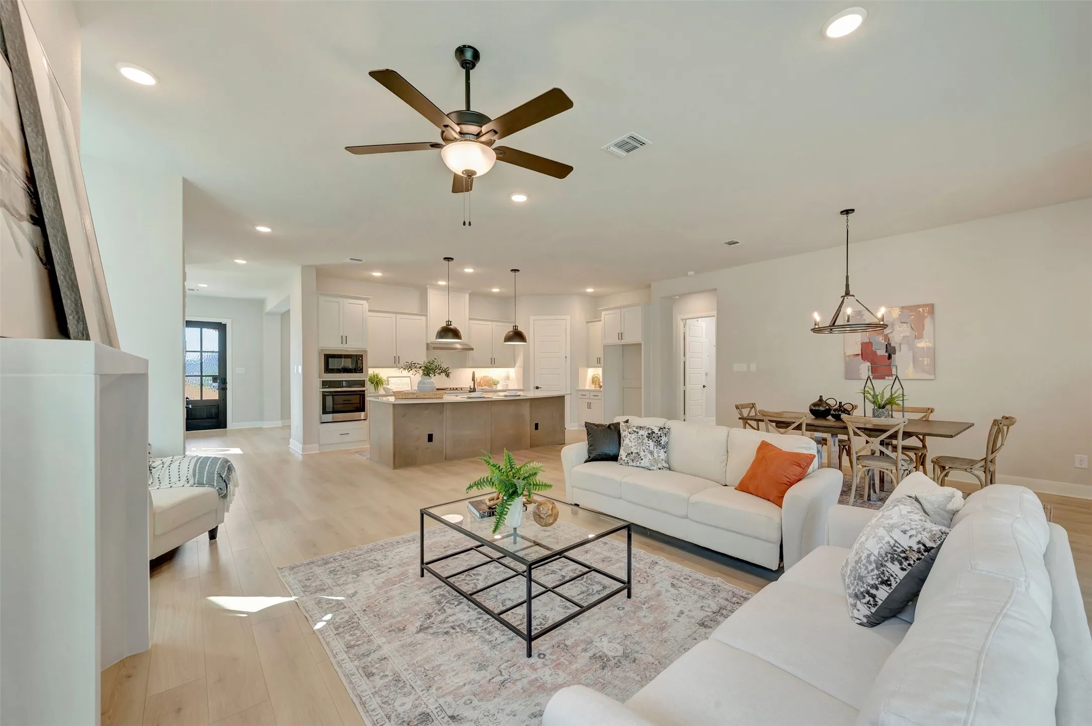 Open concept living area with wood-finish flooring, recessed lighting, and a ceiling fan