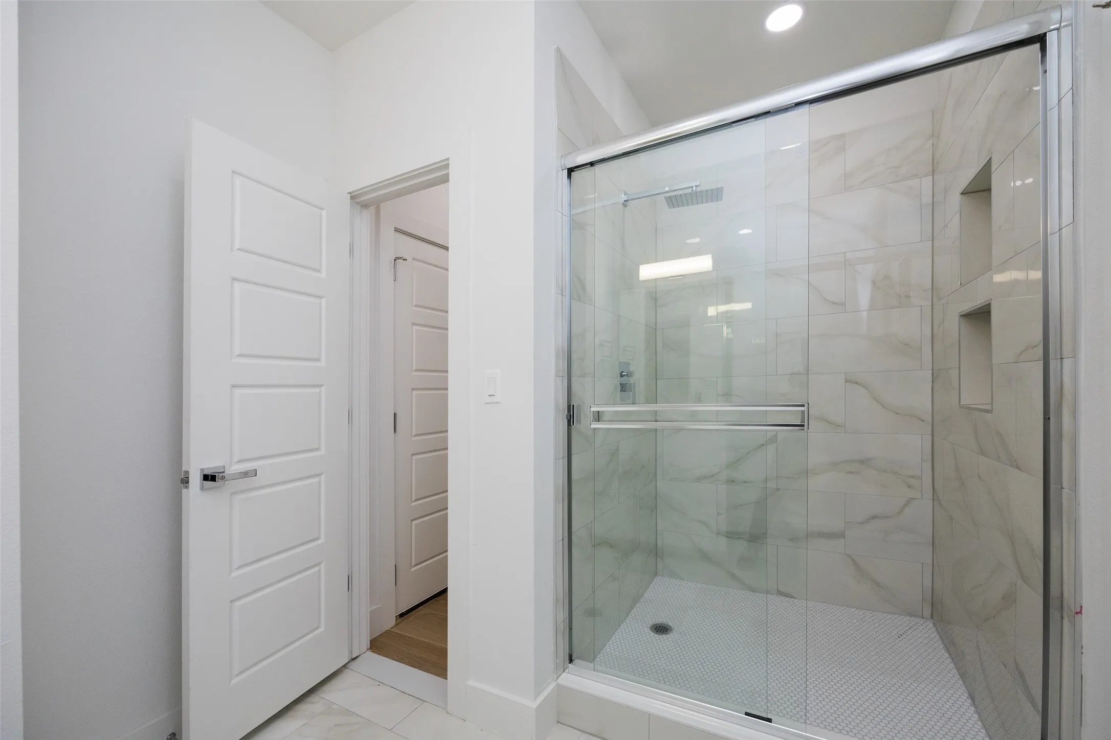 Walk-in shower with clear glass enclosure and sliding door