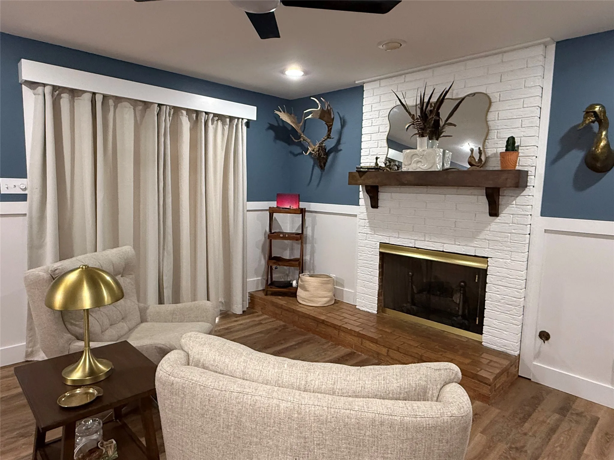 Painted brick fireplace with a wood mantel, integrated firebox, and a brick hearth