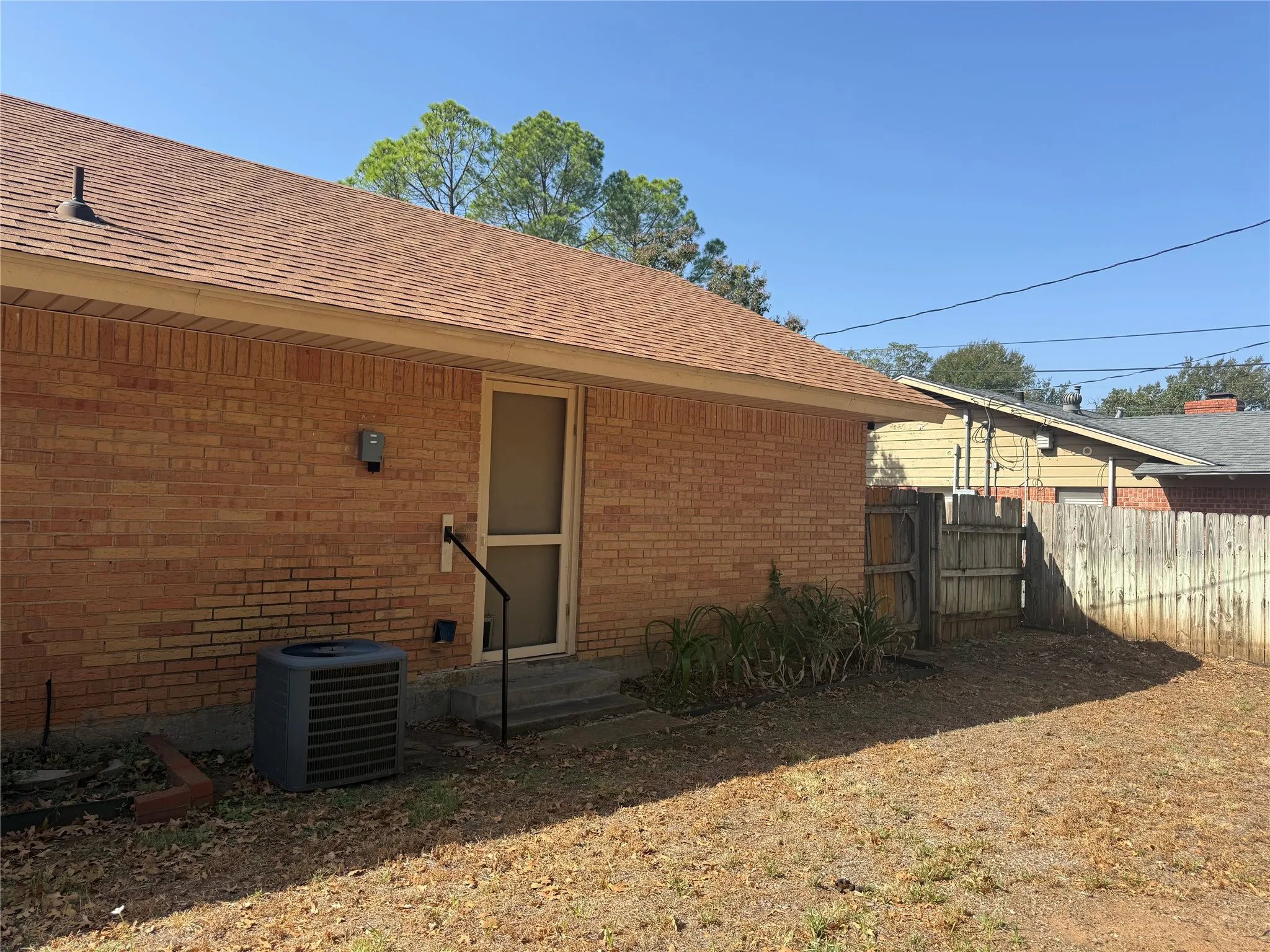 Brick exterior with a brown shingle roof