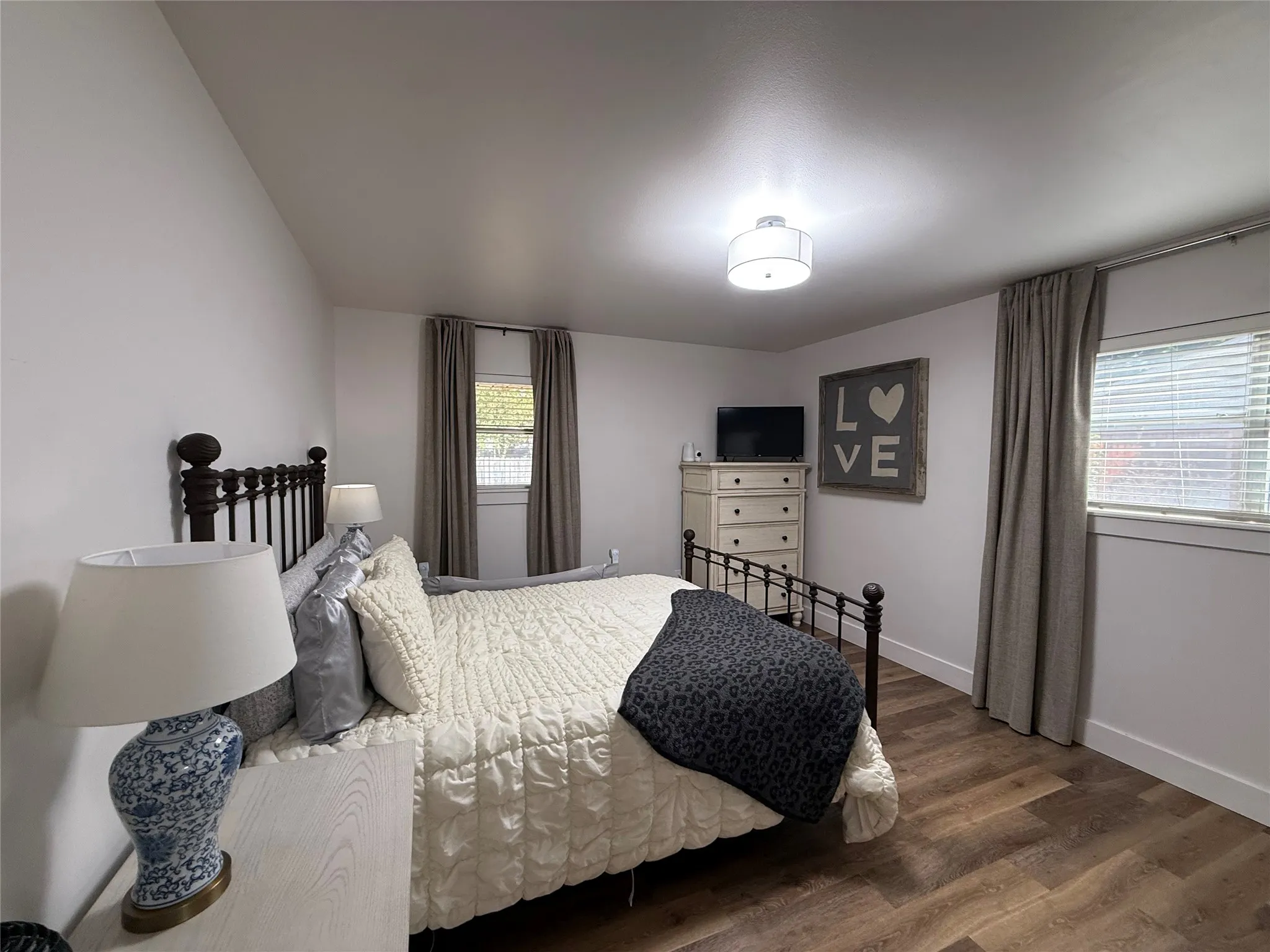 Luxury Plank flooring, white walls, and a contemporary ceiling light fixture