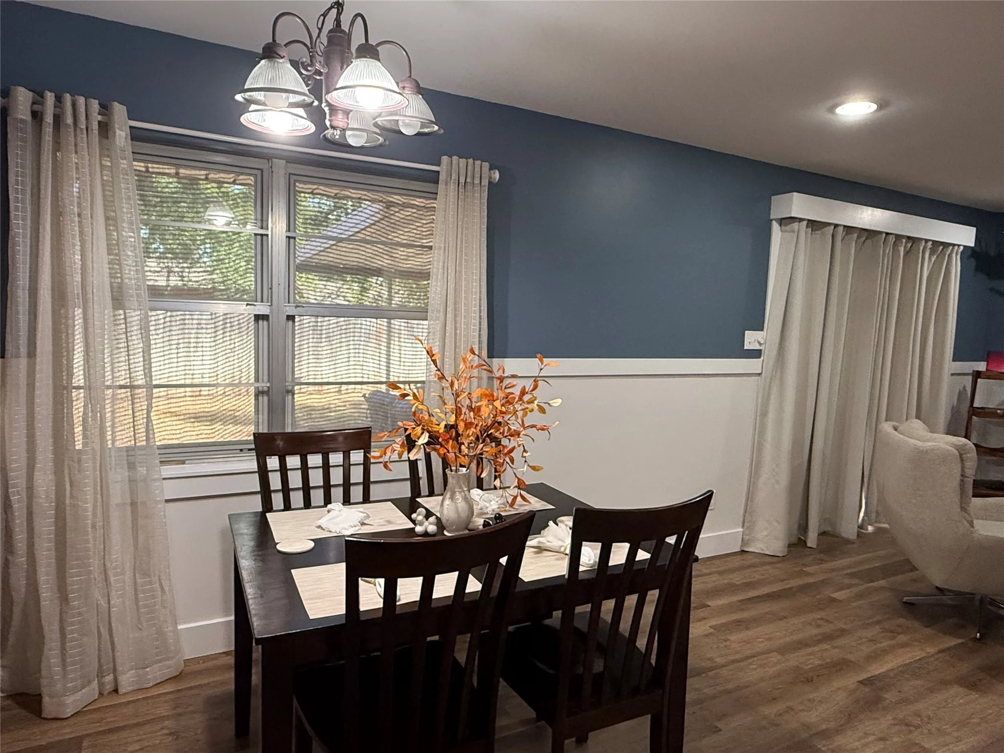 Luxury Plank flooring throughout, featuring a multi-pane window, recessed lighting, and a decorative ceiling fixture