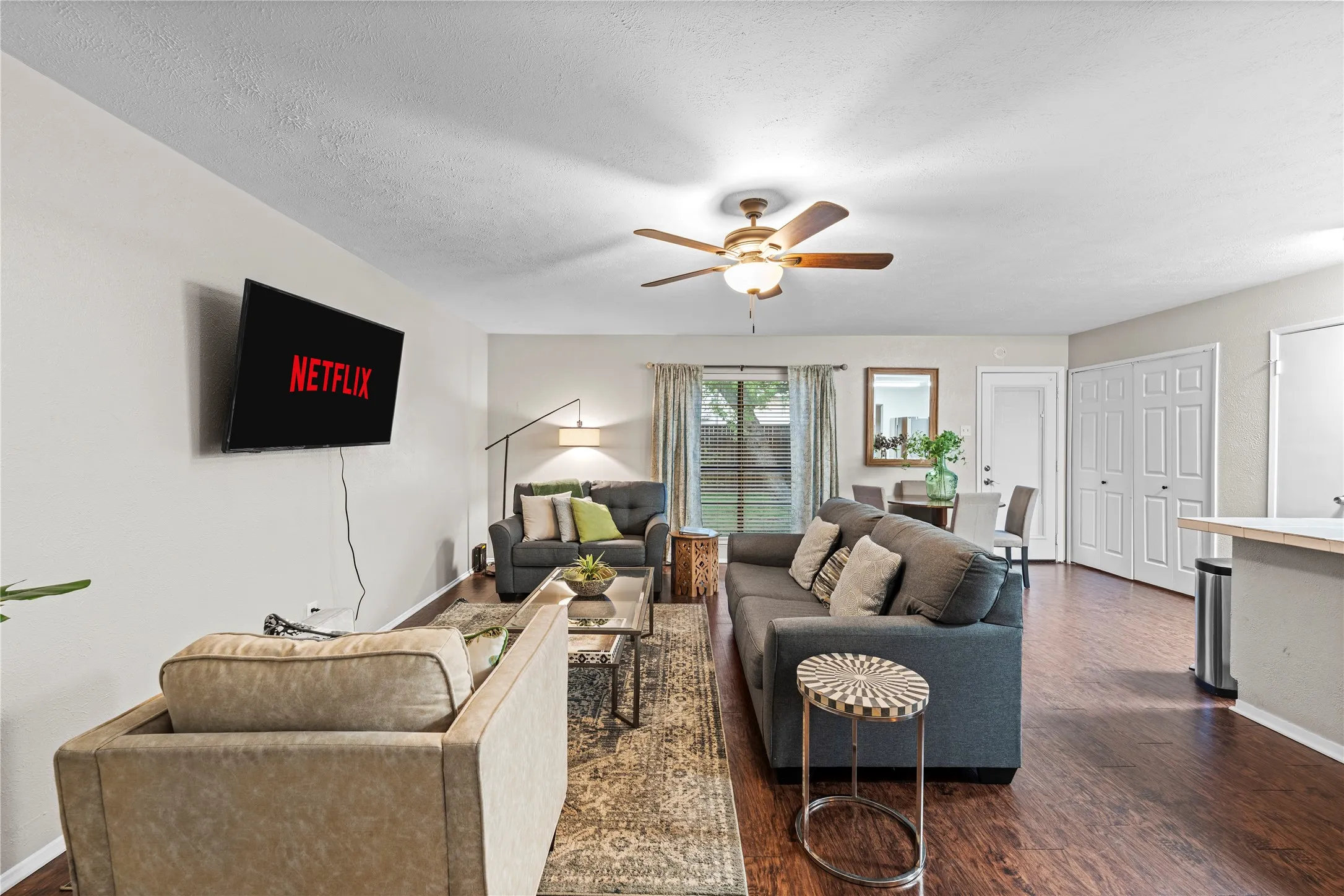 Recessed ceiling fan with integrated lighting, wood-finish flooring, light-toned wall paint, white trim, and a white paneled closet door
