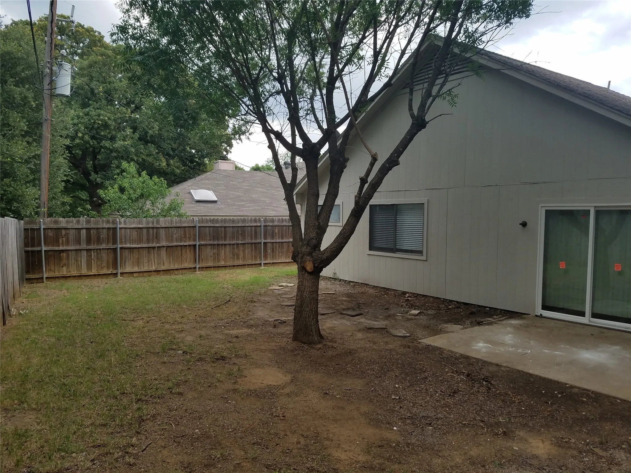 Private fenced yard featuring a mature tree