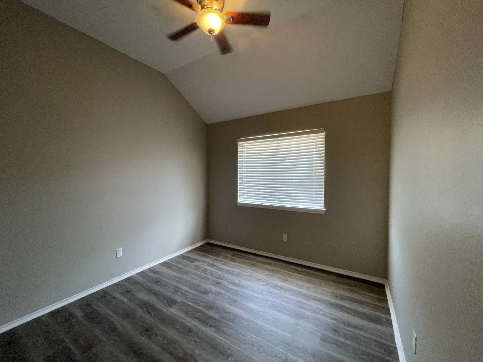 Vaulted ceiling with a ceiling fan, wood-finish flooring, and window with horizontal blinds