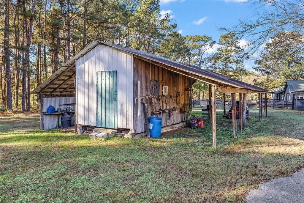 Large covered outdoor workshop or barn pavilion providing covered storage and workspace.