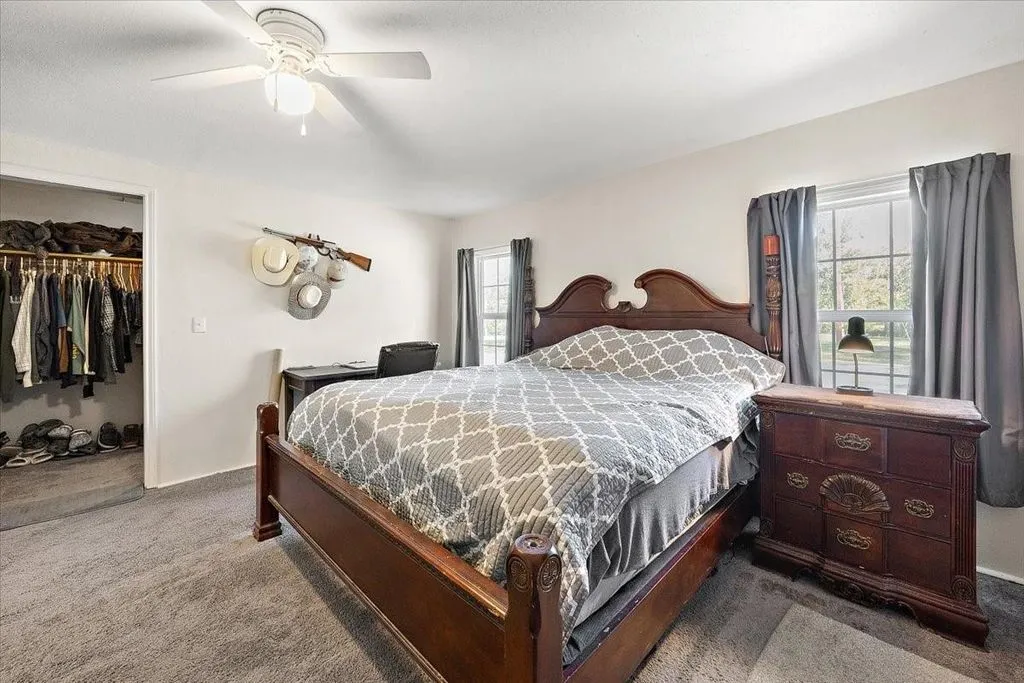 Guest bedroom layout displaying dark wood furnishings, neutral walls, and window view.