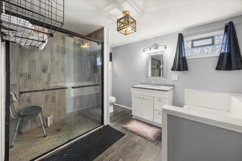 Primary en-suite bathroom equipped with a double vanity sink, walk-in glass shower enclosure, and modern fixtures.