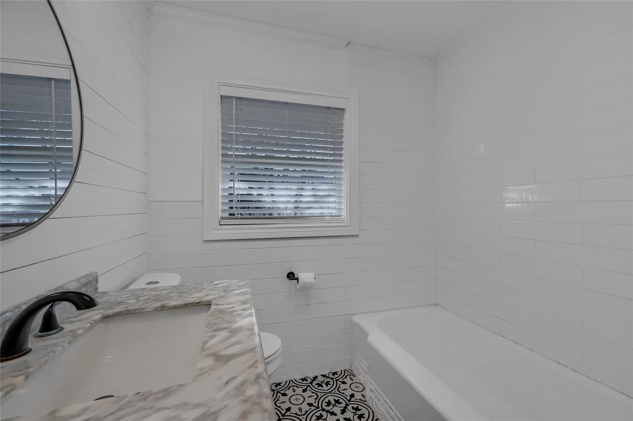 Bathroom with a tub to relax in, vanity, tile patterned flooring, and toilet
