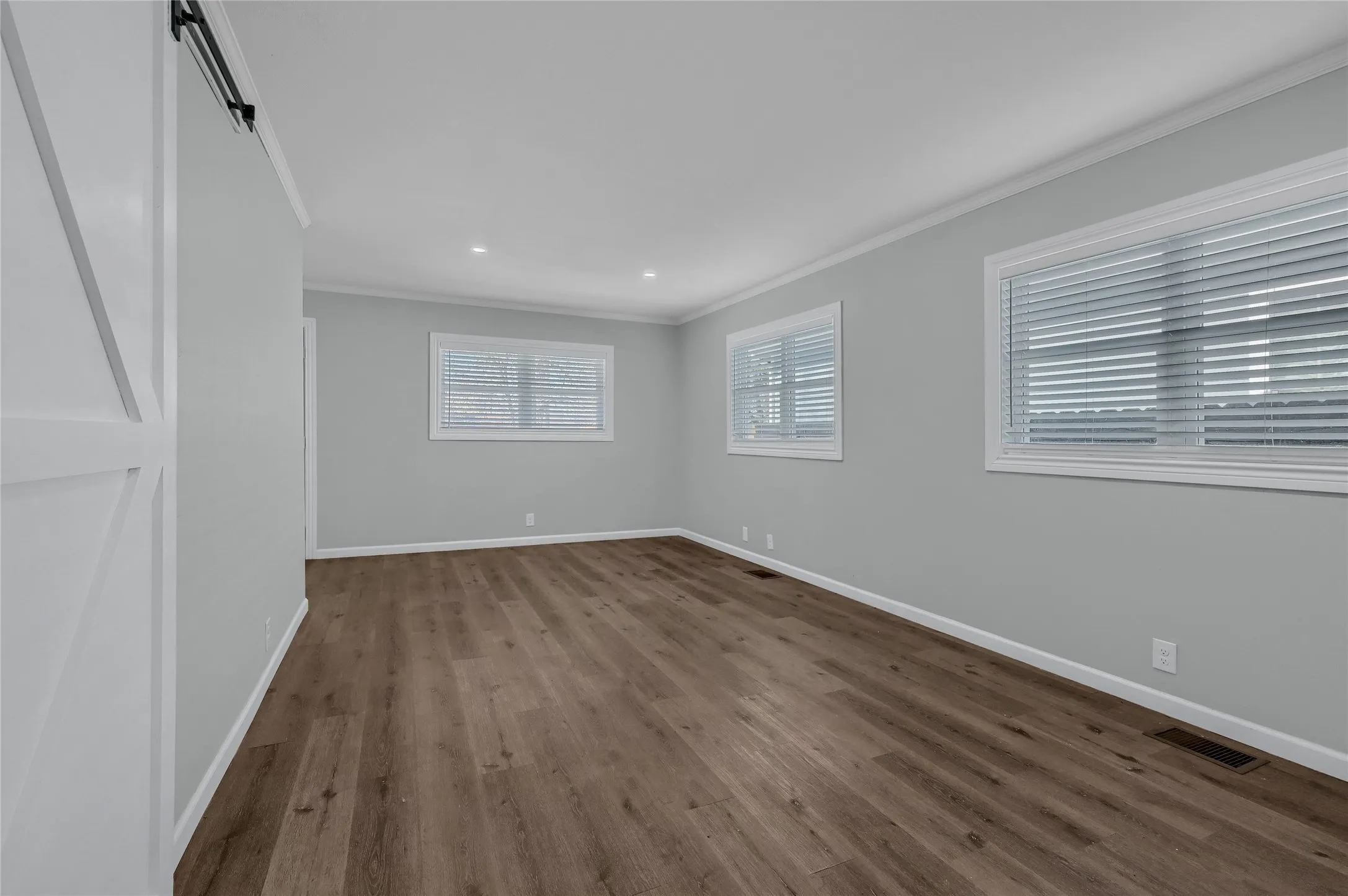 Spare room with crown molding and wood-type flooring