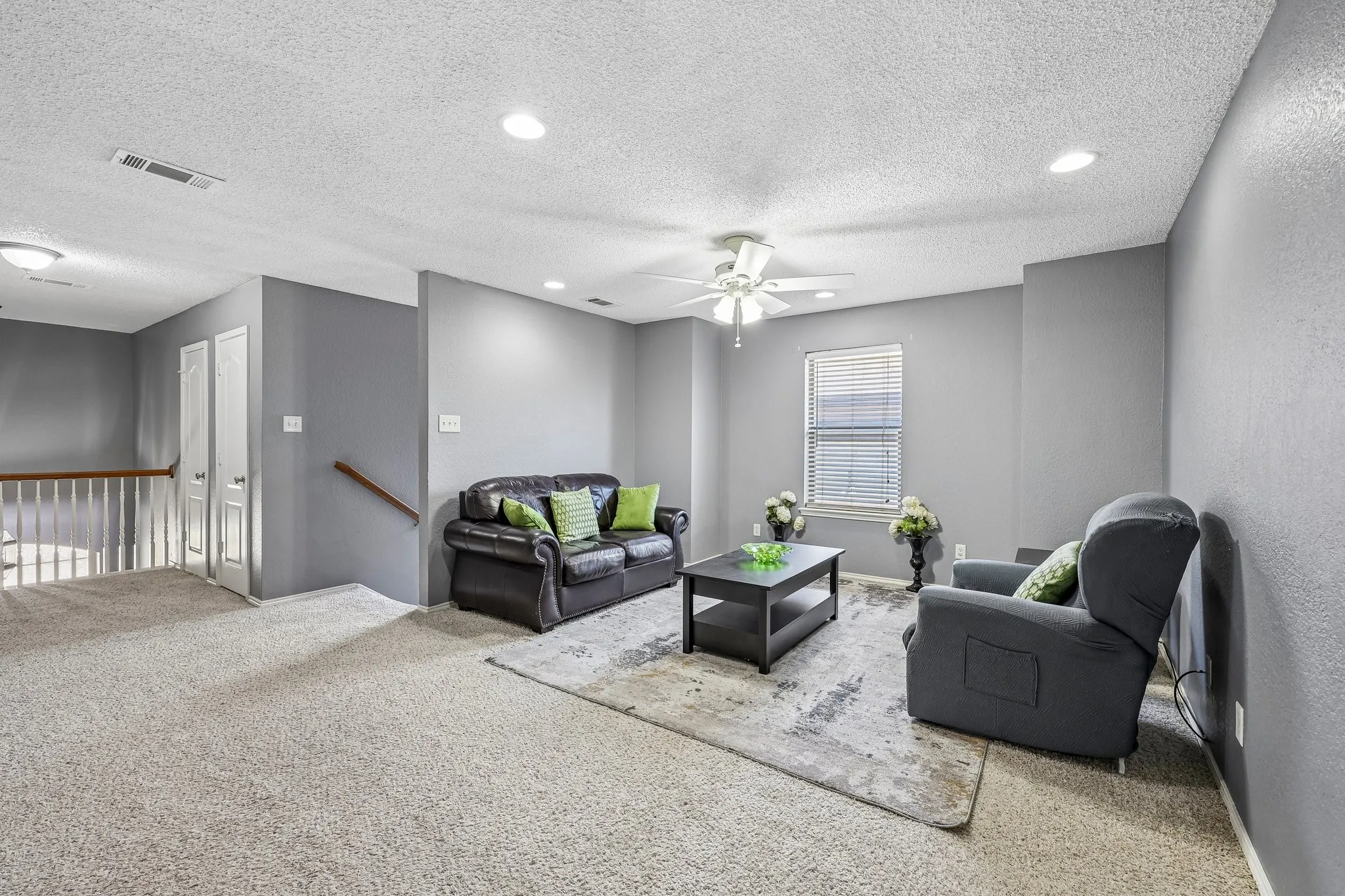 Spacious carpeted room featuring recessed lighting, a ceiling fan, and a window with horizontal blinds
