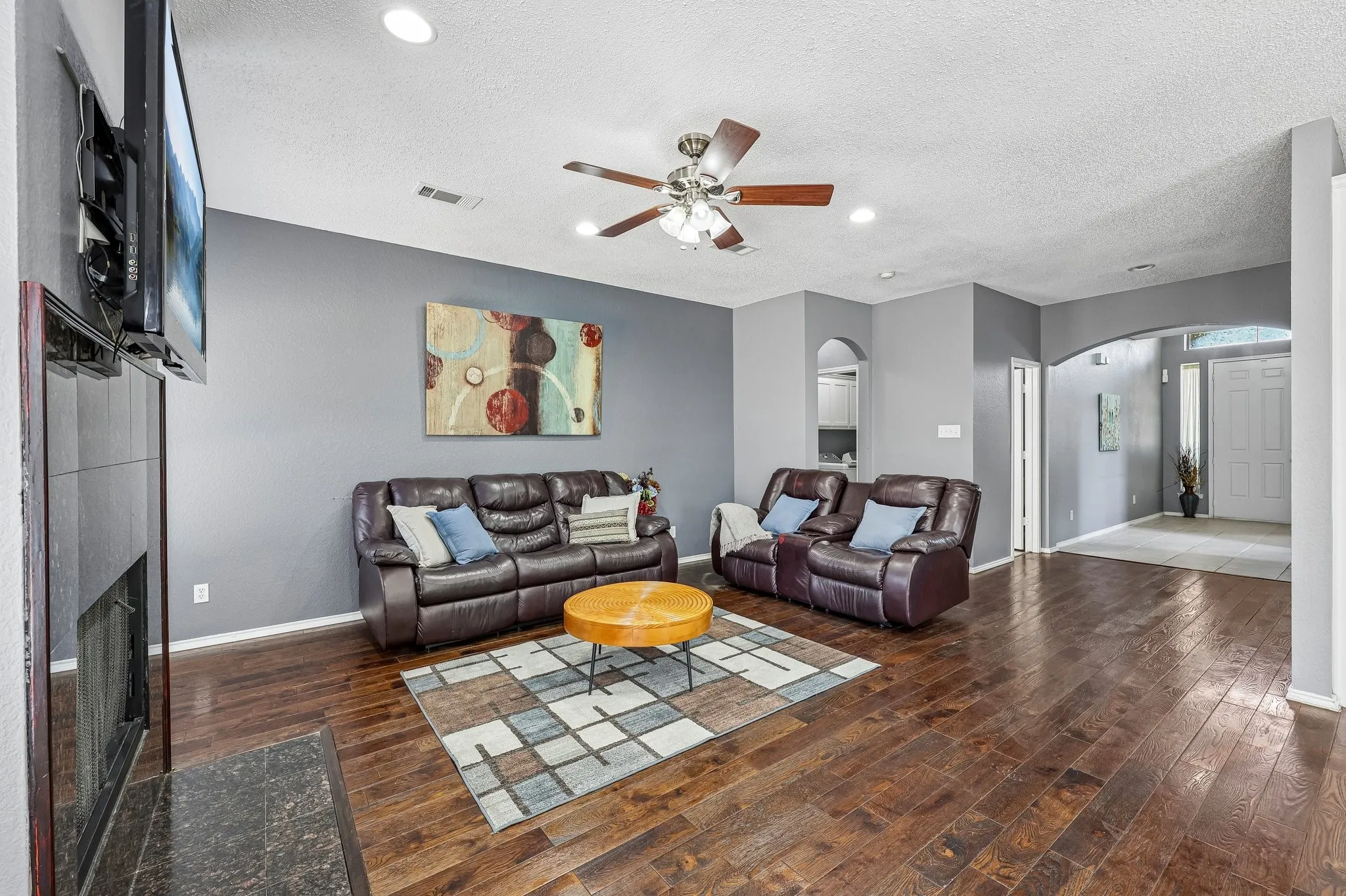 Living area featuring rich wood-finish flooring, recessed lighting, and a ceiling fan
