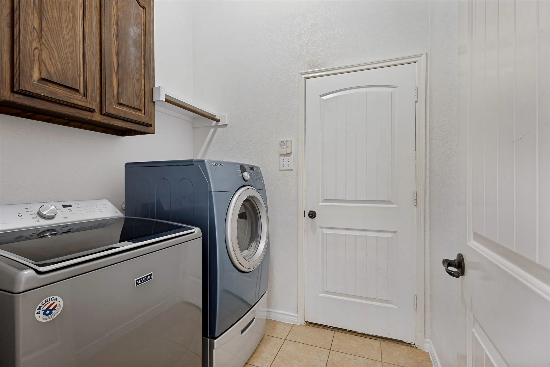 Built-in wood cabinetry, tiled flooring, and a white paneled door