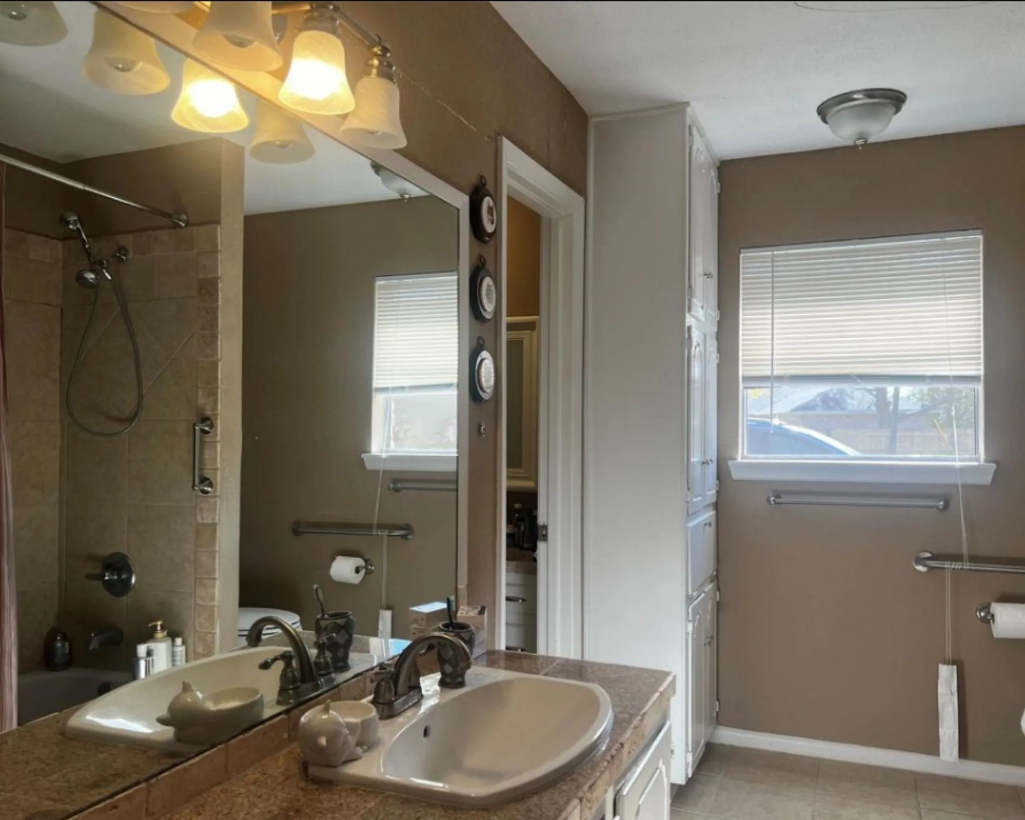 Vanity with integrated sink, stone-finish countertop, and wall-mounted lighting fixture