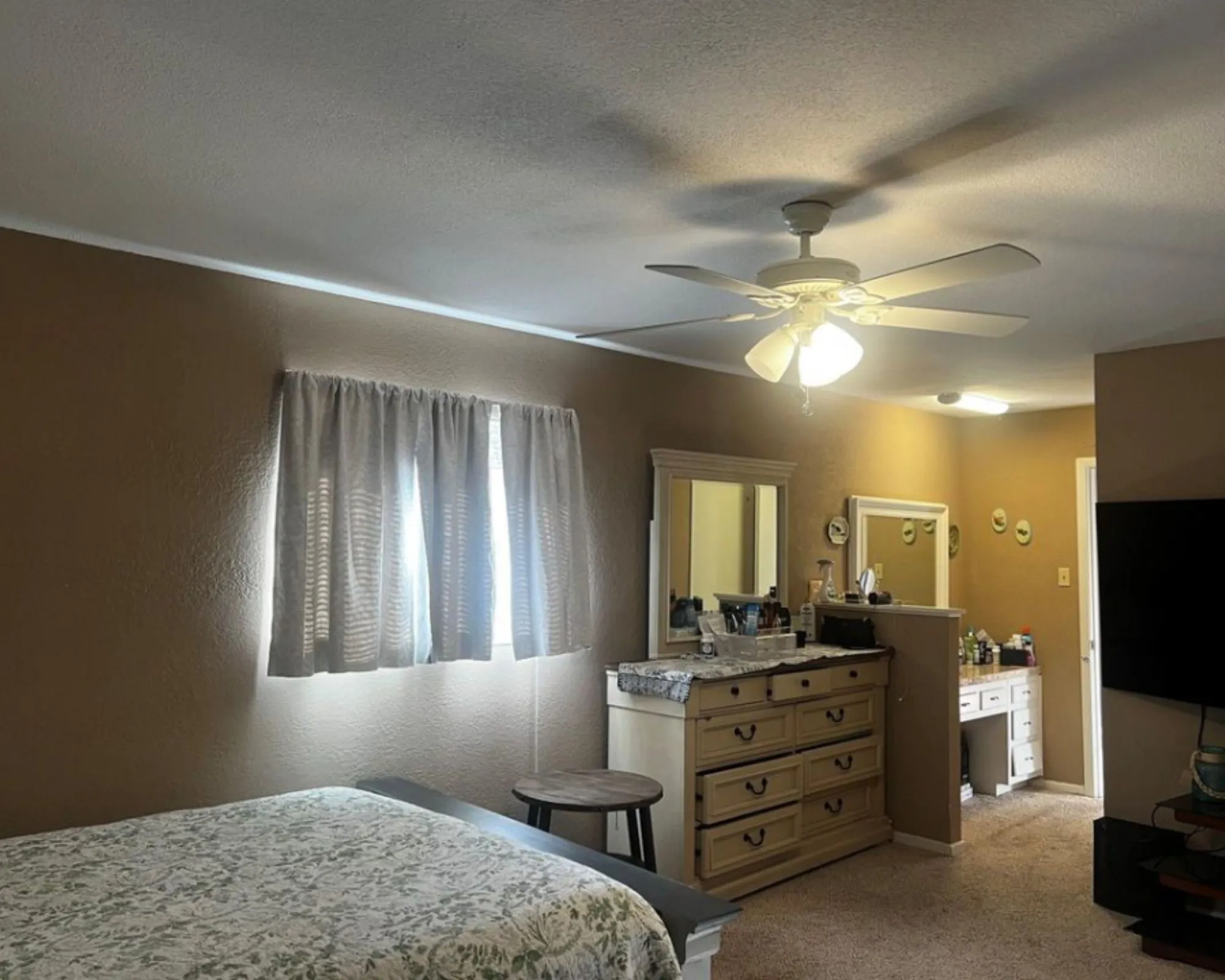 Ceiling fan with integrated lighting, wall-mounted television, recessed lighting, and a window with natural light