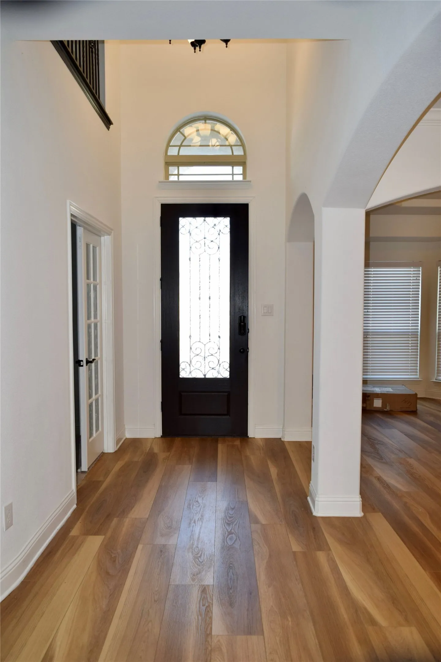 Entryway with a towering ceiling and wood-type flooring