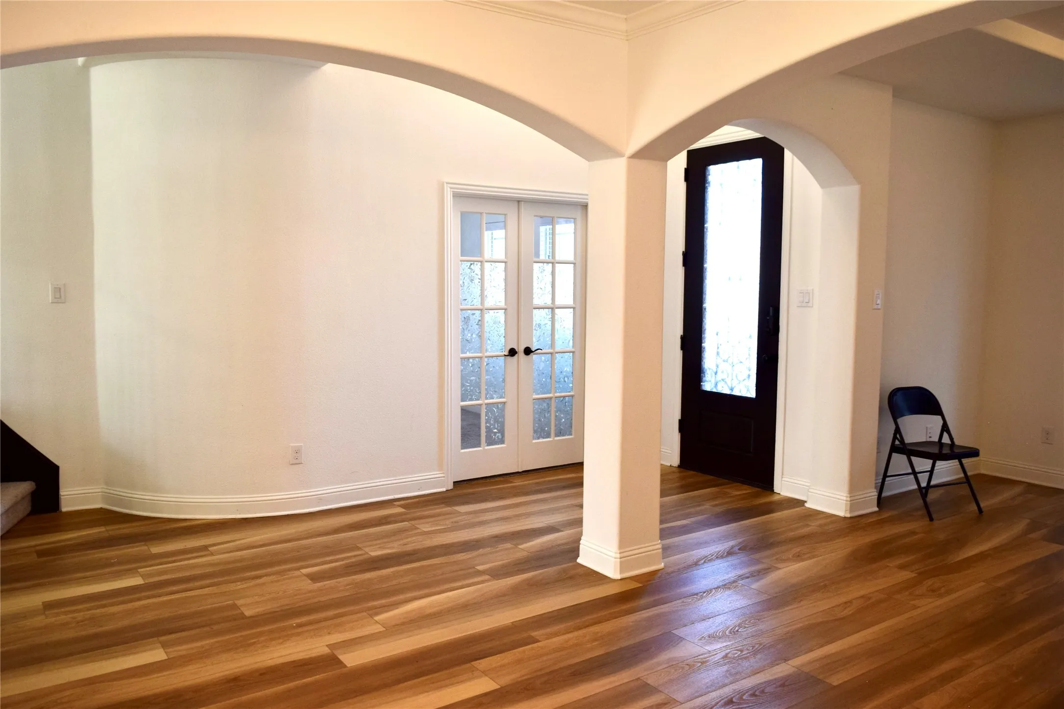 Entrance foyer featuring french doors, dark hardwood / wood-style flooring, and ornamental molding