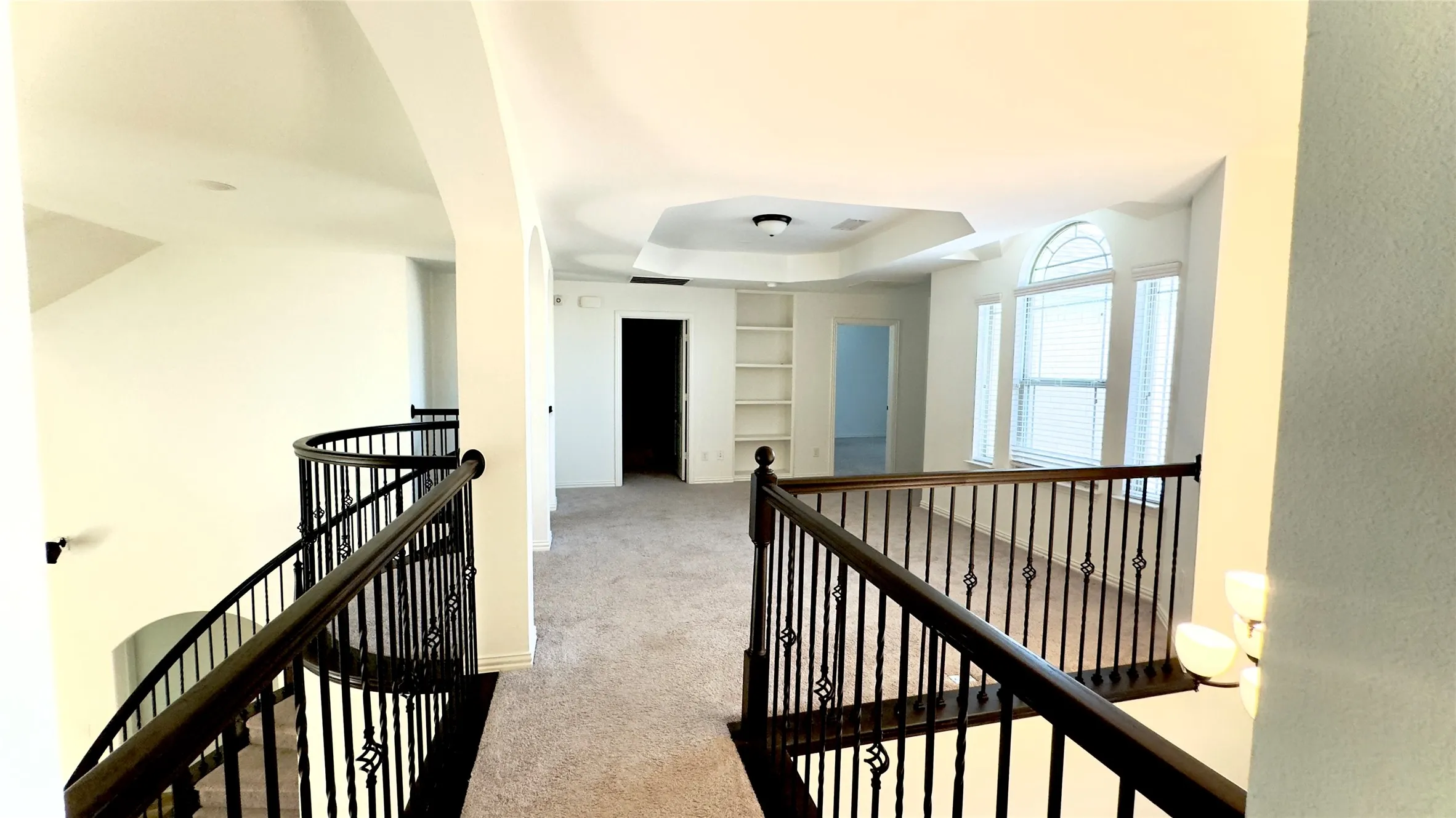 Hallway featuring built in features and light colored carpet
