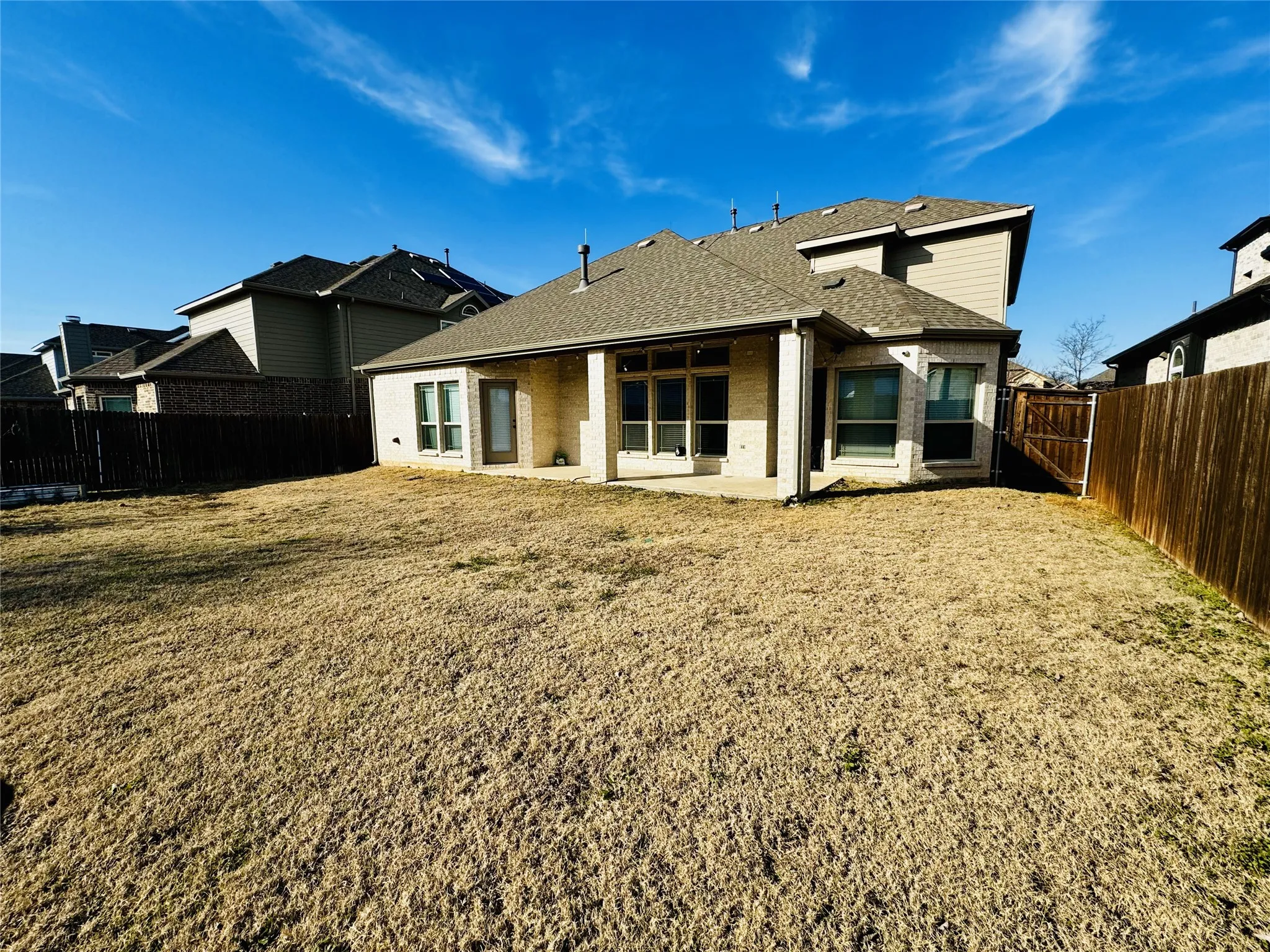 Rear view of property featuring a lawn and a patio area