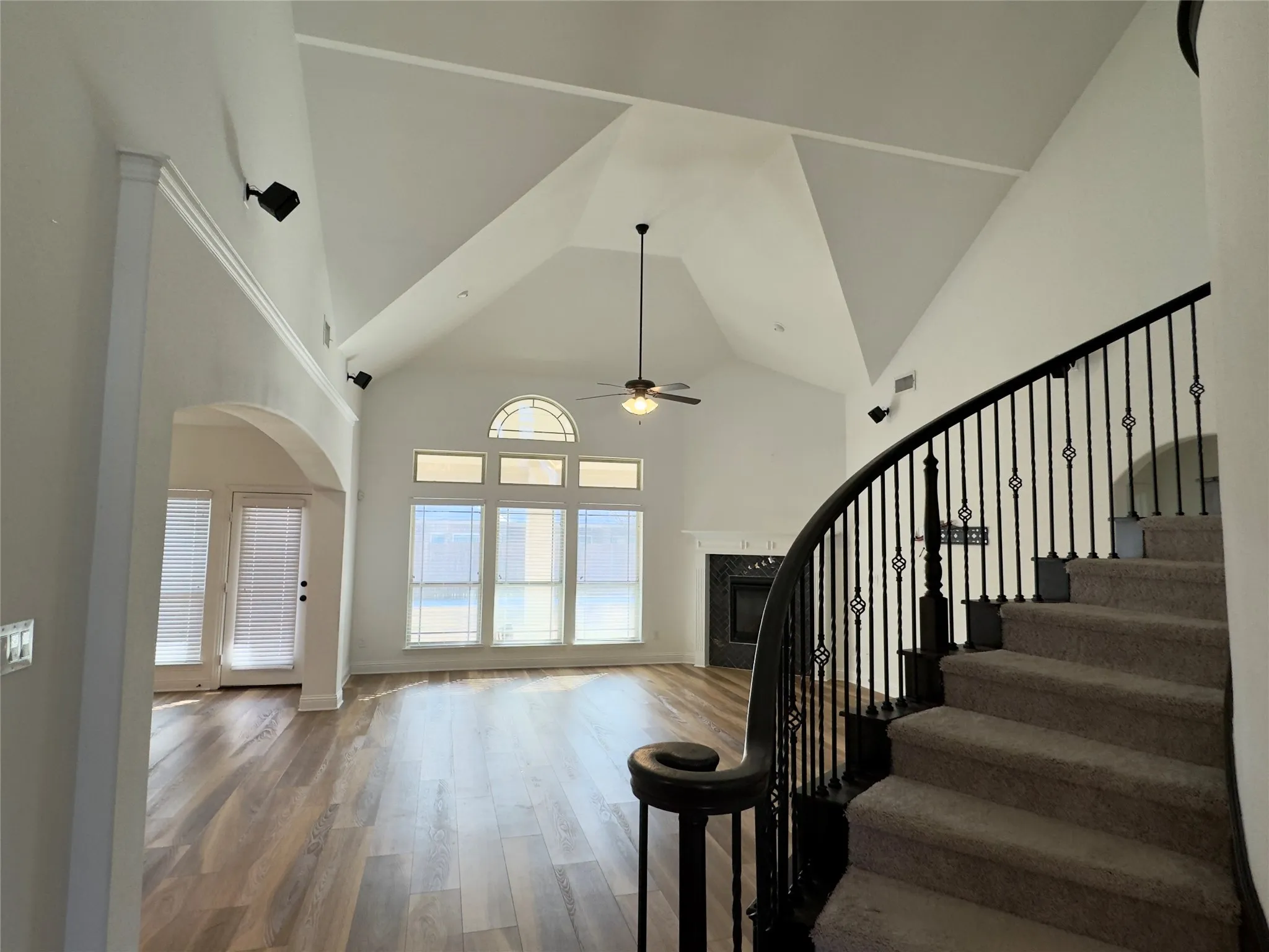 Staircase featuring ceiling fan and hardwood / wood-style flooring