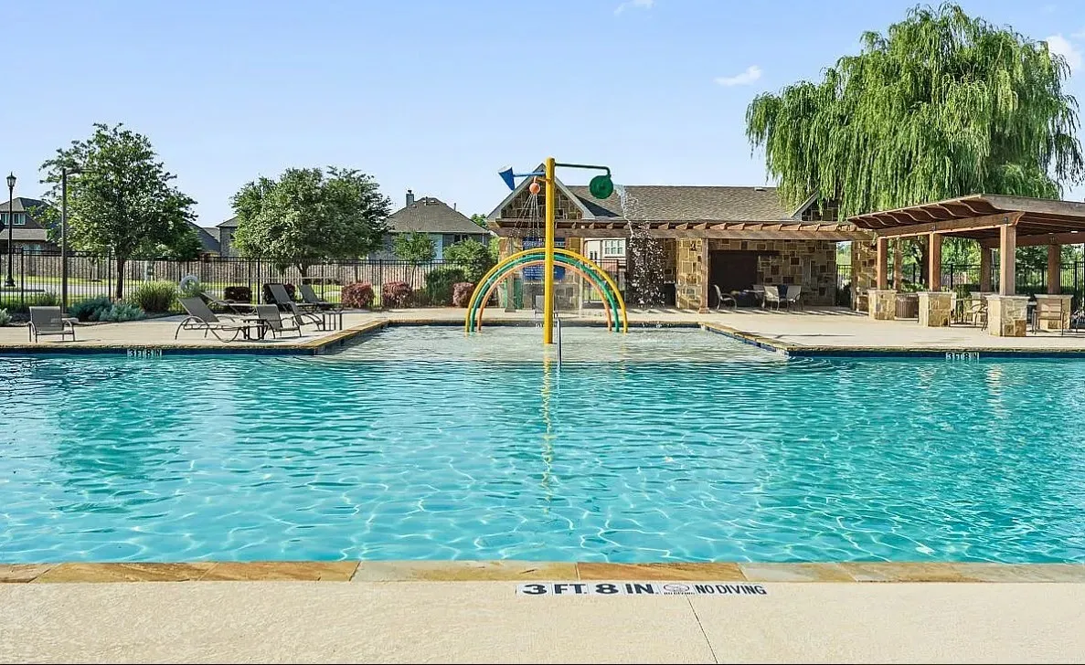 View of community swimming pool featuring a pergola, a playground, and a patio