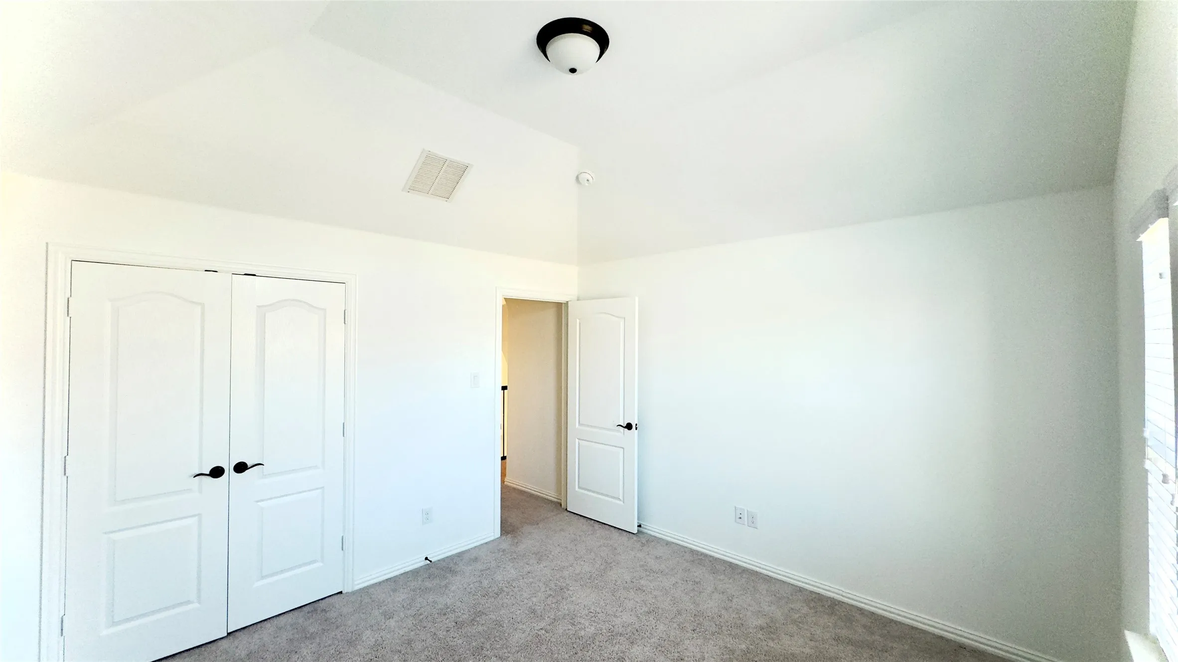 Unfurnished bedroom with a closet, light carpet, and vaulted​​‌​​​​‌​​‌‌​‌‌​​​‌‌​‌​‌​‌​​​‌​​ ceiling