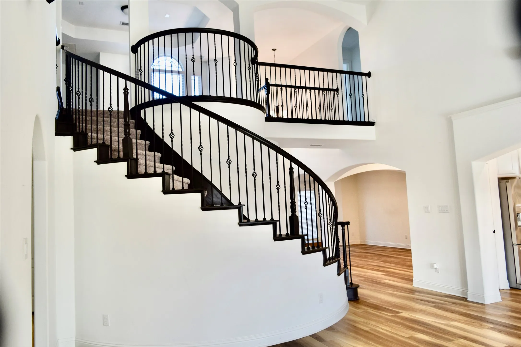 Stairs with a high ceiling and wood-type flooring
