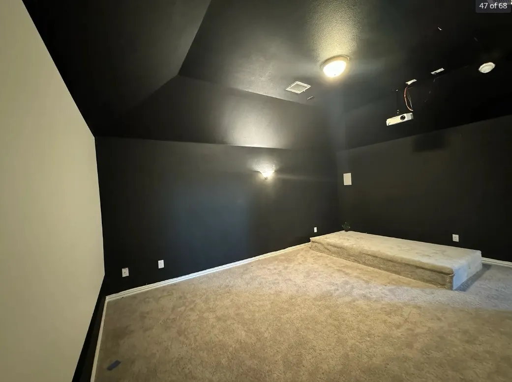 Home theater room with a textured ceiling and carpet