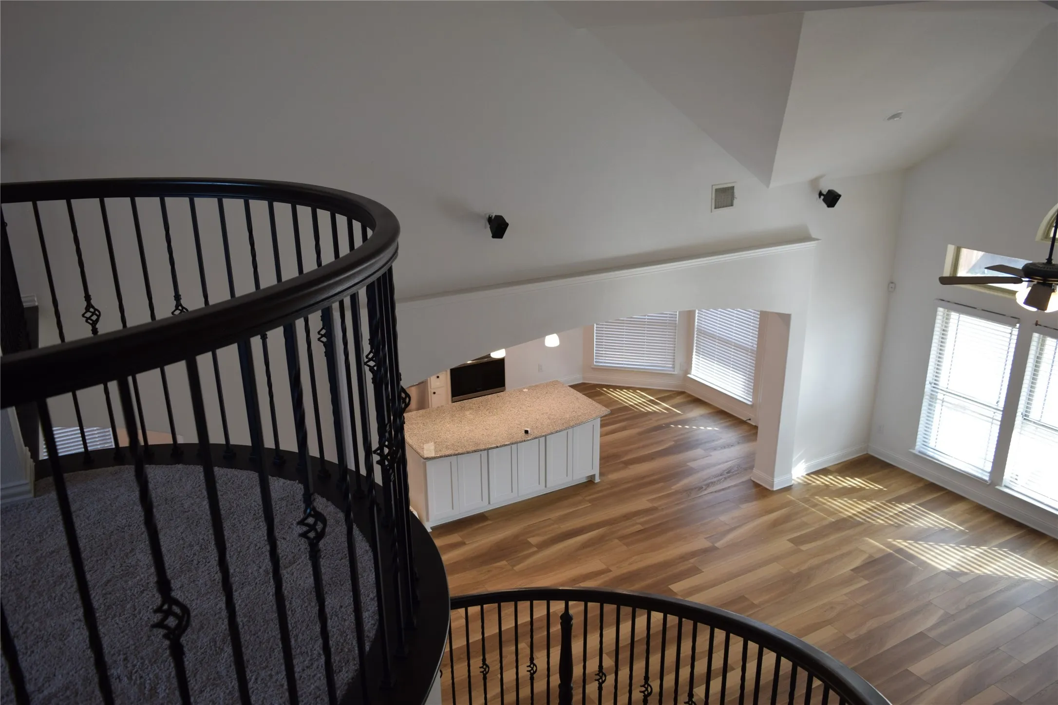 Stairway with lofted ceiling and hardwood / wood-style floors