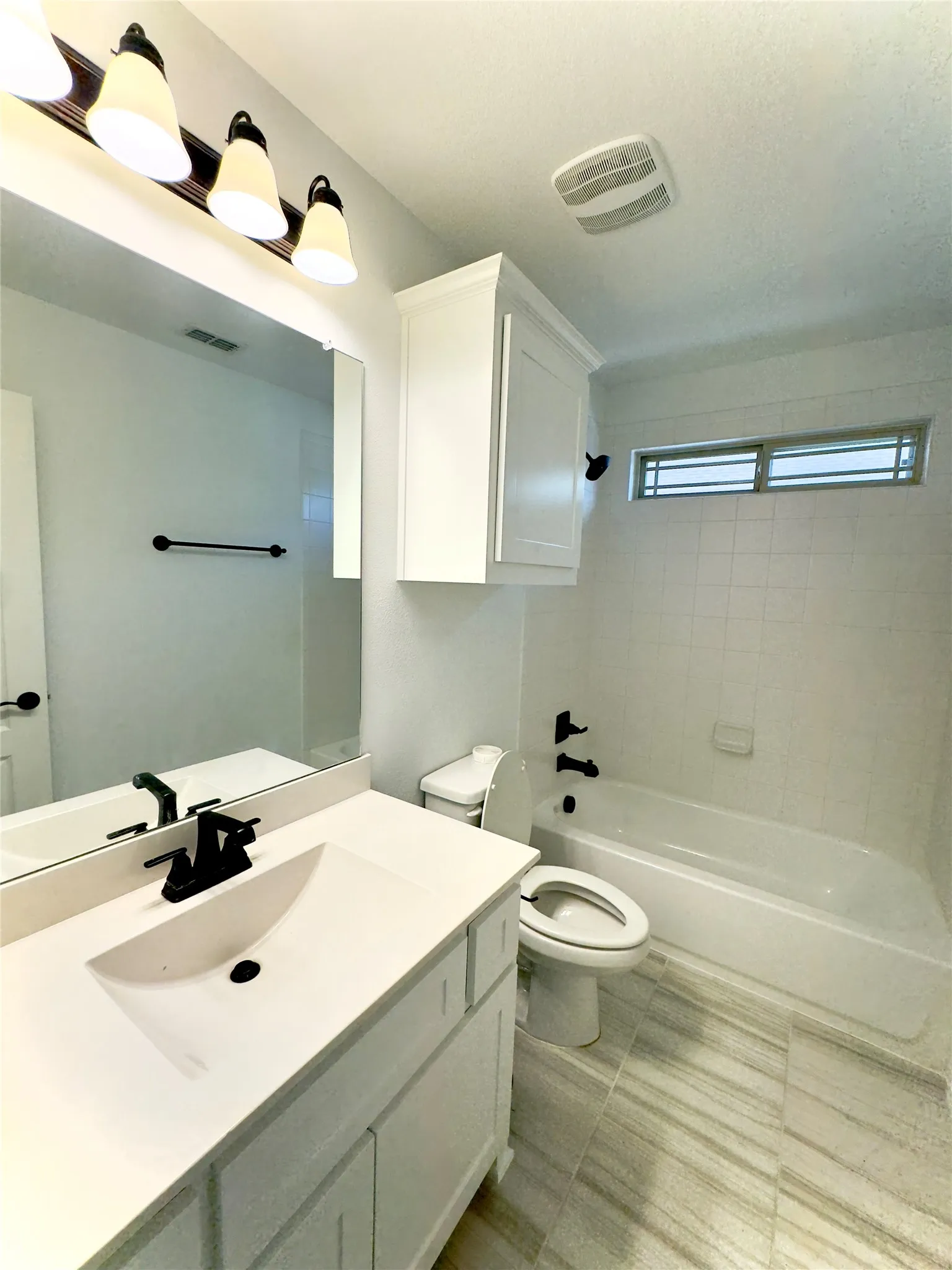 Full bathroom featuring toilet, vanity, and tiled shower / bath