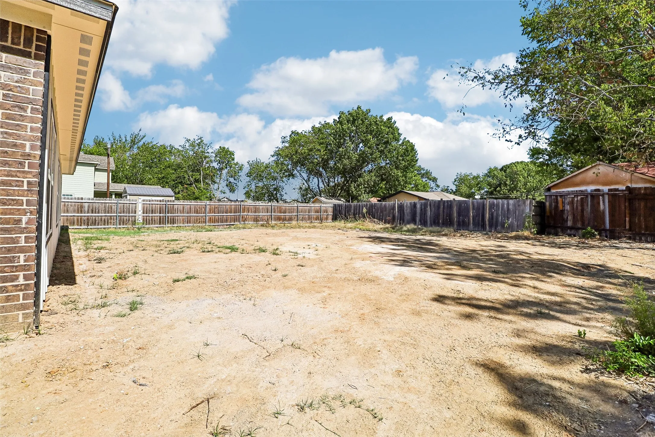 Expansive undeveloped lot with existing perimeter fencing and mature trees
