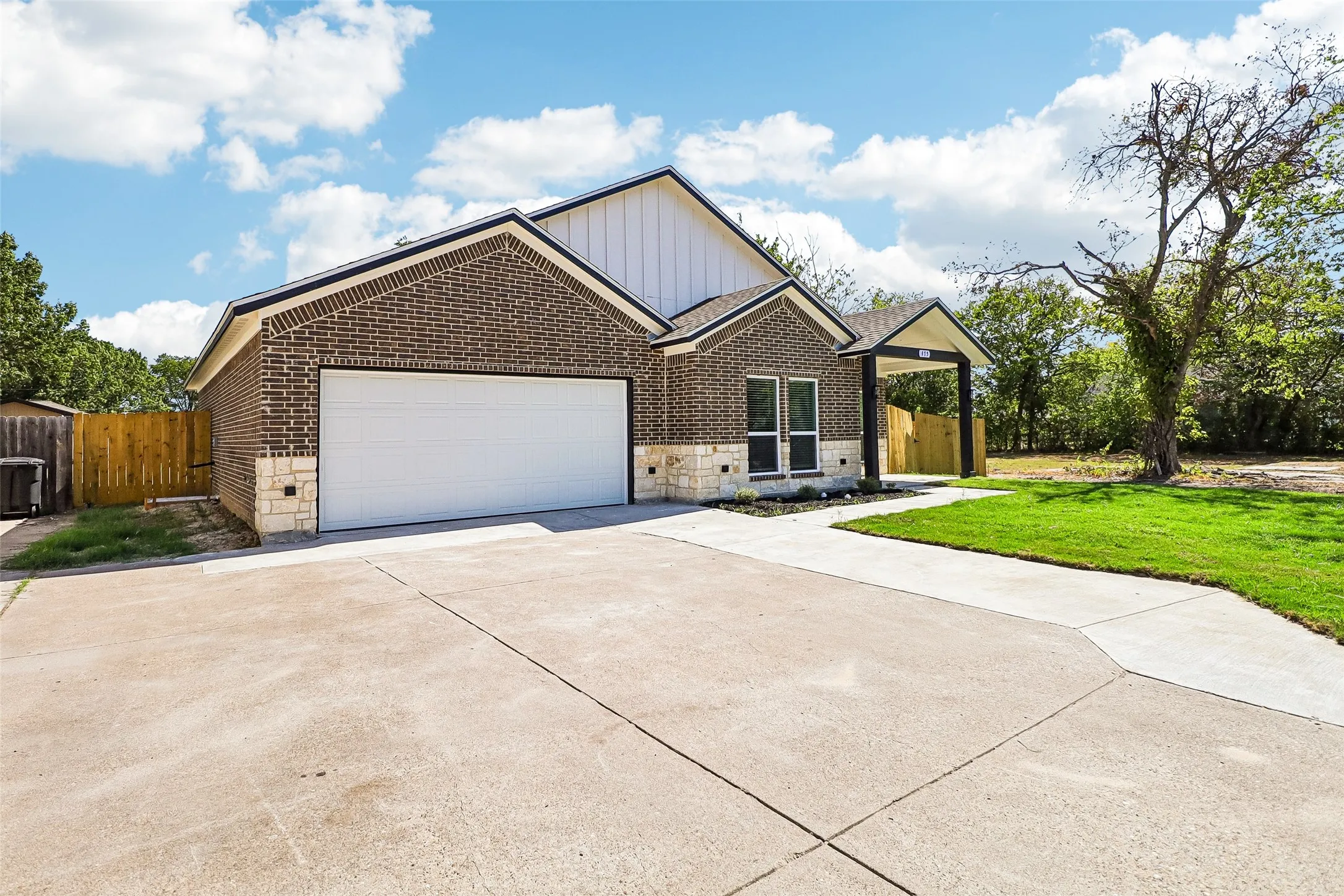 Brick exterior with stone accents, covered entry, and a two-car garage