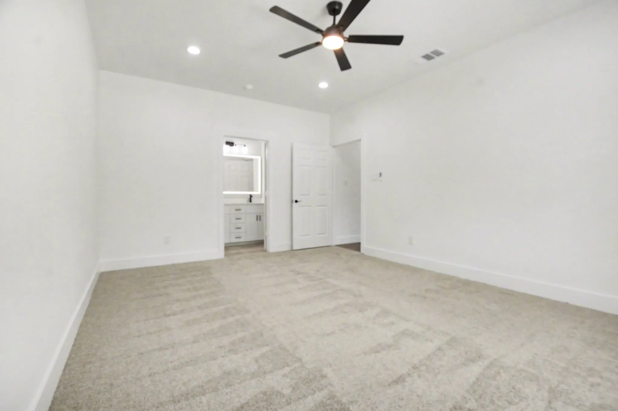 Spacious room with plush carpet flooring, recessed lighting, and a ceiling fan