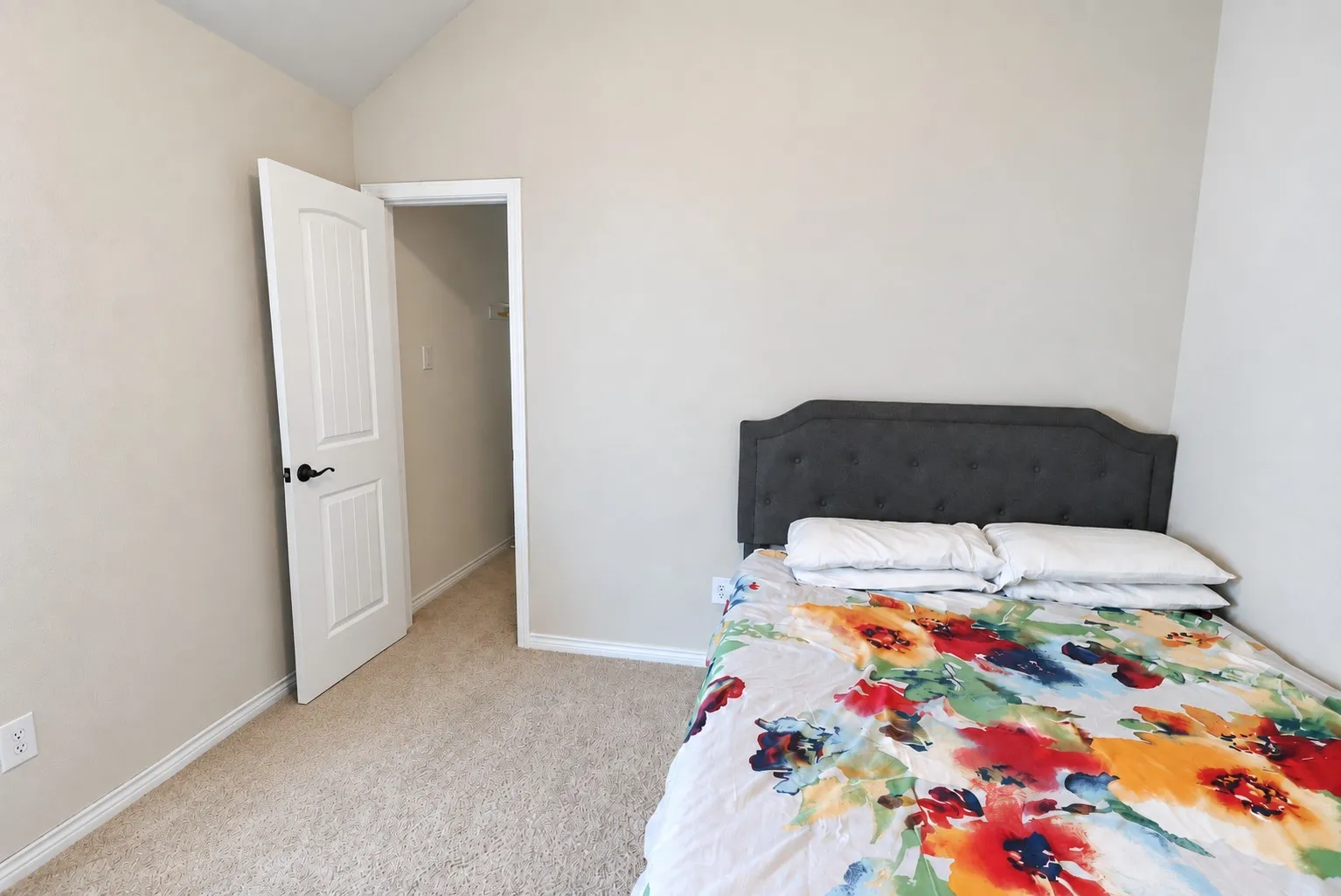 Carpeted flooring, vaulted ceiling, and painted walls