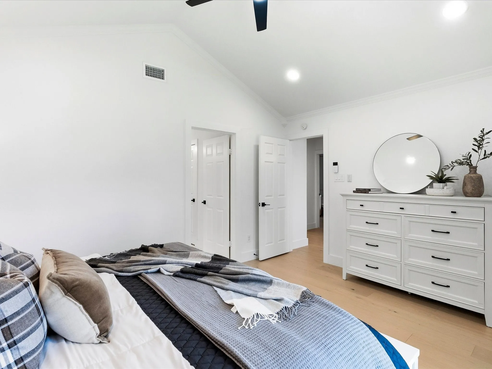 Vaulted ceiling with a ceiling fan, recessed lighting, white panel doors, and wood-finish flooring