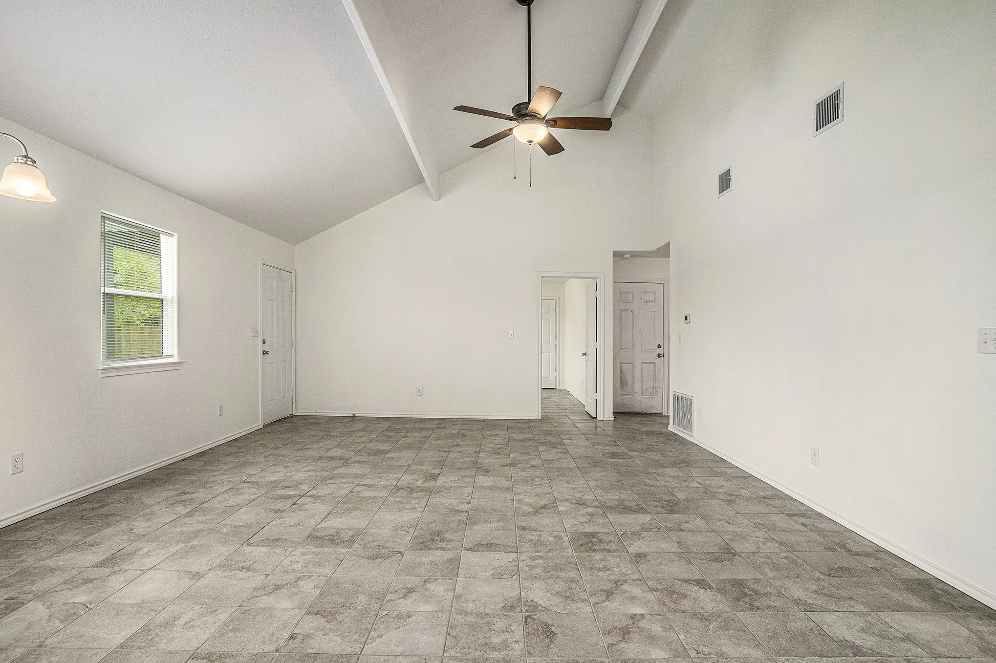 Vaulted ceiling with a ceiling fan, tile flooring, window with natural light, and recessed lighting