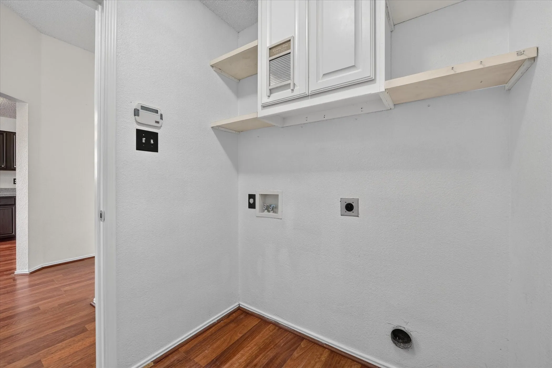 Dedicated laundry room featuring hookups for washer and dryer, additional storage space, and convenient access to main living zones.